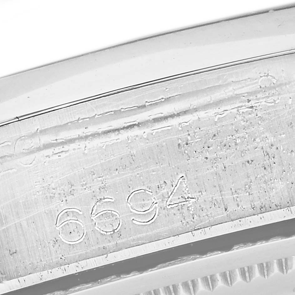 This image shows a close-up of the serial number "6694" engraved on the case of a Rolex Vintage Collection 6694 Men's Stainless Steel Black Dial 6694 Men's Stainless Steel Black Dial model watch.