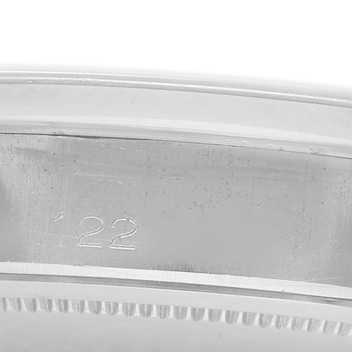 The image shows a close-up of the side edge of a Rolex Vintage Collection 6694 Men
s Stainless Steel Pink Dial watch, highlighting the bezel and part of the case with engraved numbers.