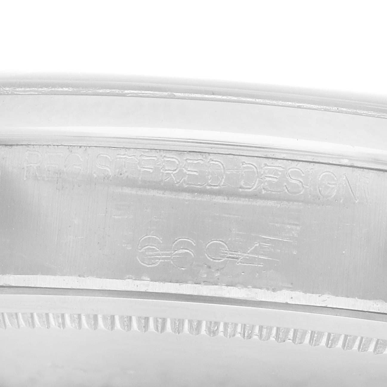 The image shows a close-up of the side engraving on the bezel of a Rolex Vintage Collection 6694 Men
s Stainless Steel Pink Dial watch.