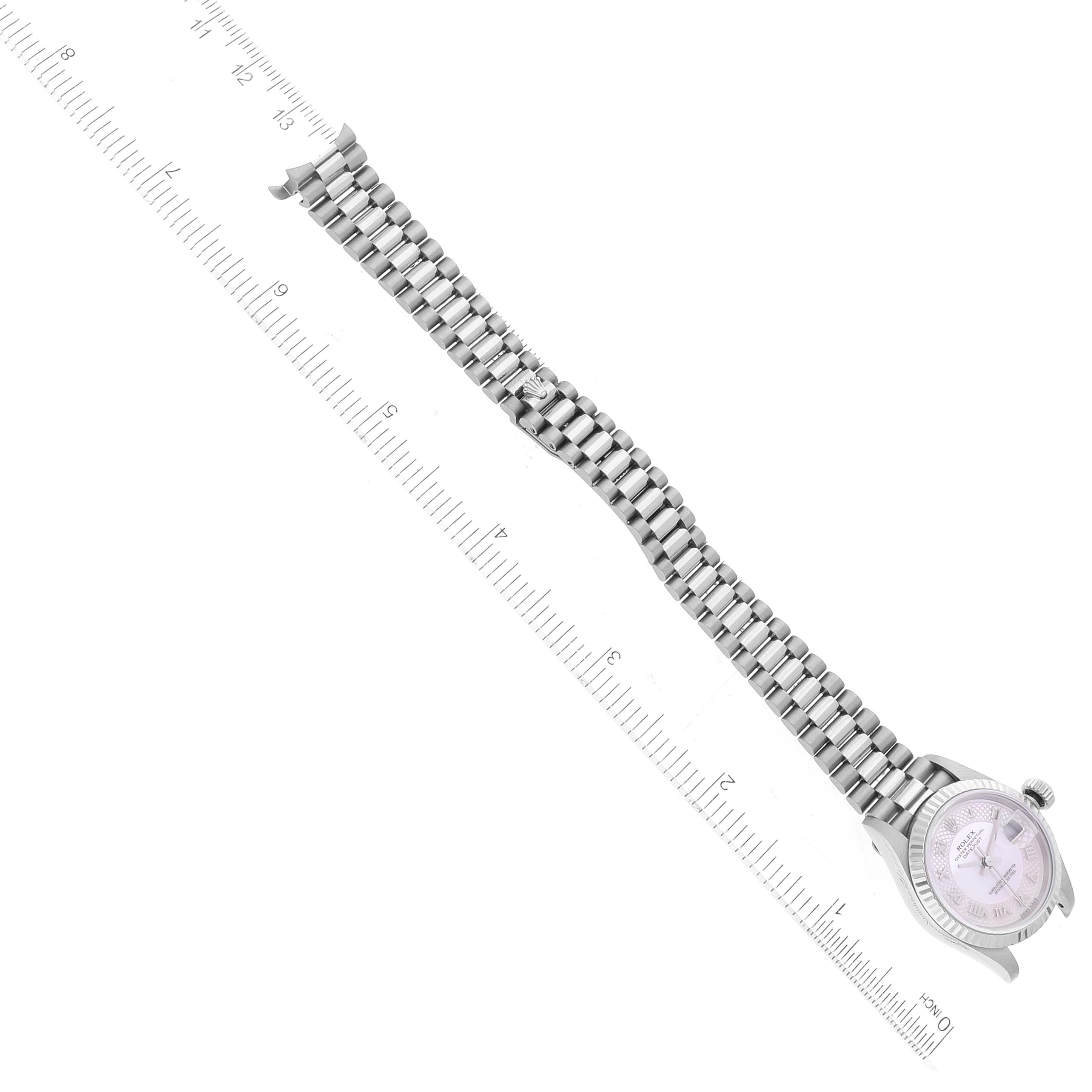 The image shows a Rolex President 79179 Women's White Gold Mother of Pearl Dial 79179 Women's White Gold Mother of Pearl Dial model watch positioned with the dial on the left and the bracelet aligned with a ruler.