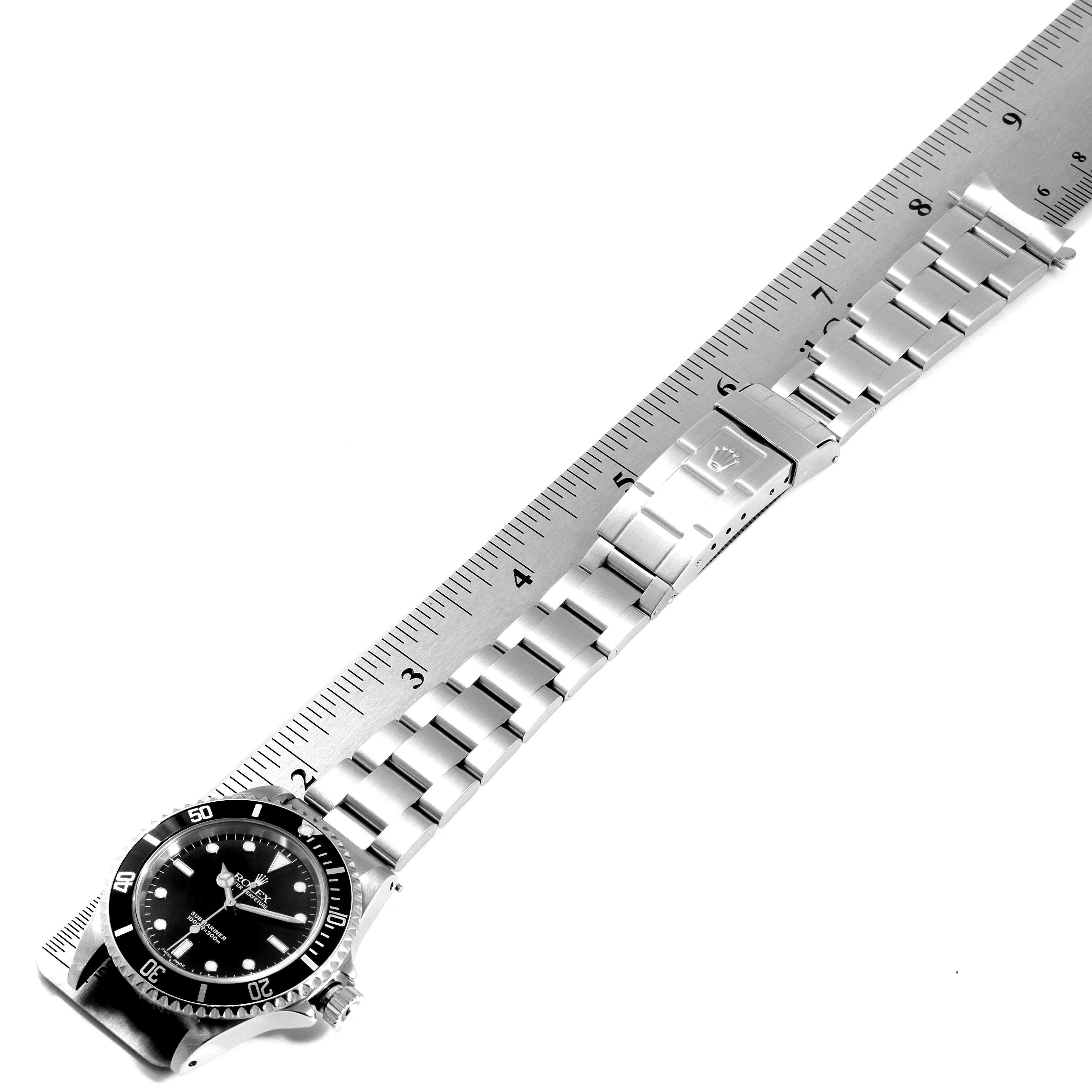 The image shows a top-down view of a Rolex Submariner 14060 Men
s Stainless Steel Black Dial 14060 Men
s Stainless Steel Black Dial watch with a stainless steel bracelet measured against a metal ruler.