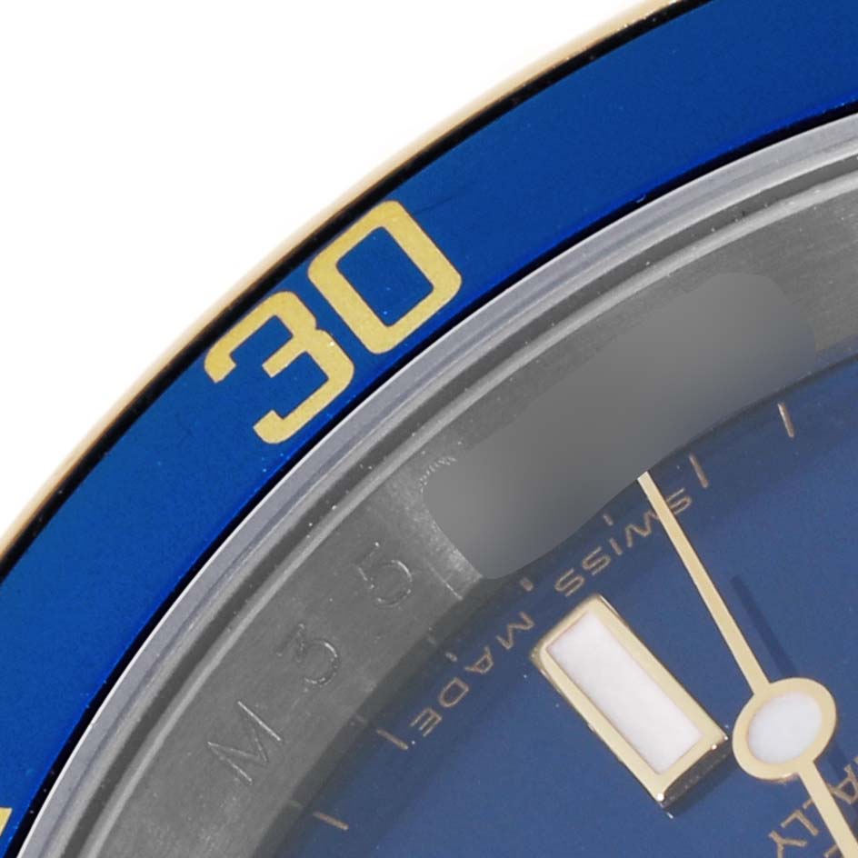 The image shows a close-up of a blue and gold bezel, dial, and part of the hands of a Rolex Submariner 16613 Men's Steel and Gold (two tone) Blue Dial 16613 Men's Steel and Gold (two tone) Blue Dial watch.
