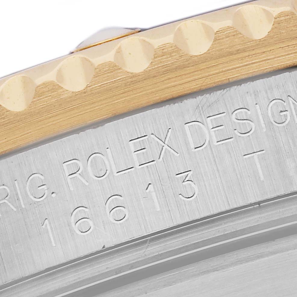This close-up image shows the engraved serial number and part of the bezel of the Rolex Submariner 16613 Men's Steel and Gold (two tone) Blue Dial 16613 Men's Steel and Gold (two tone) Blue Dial watch.