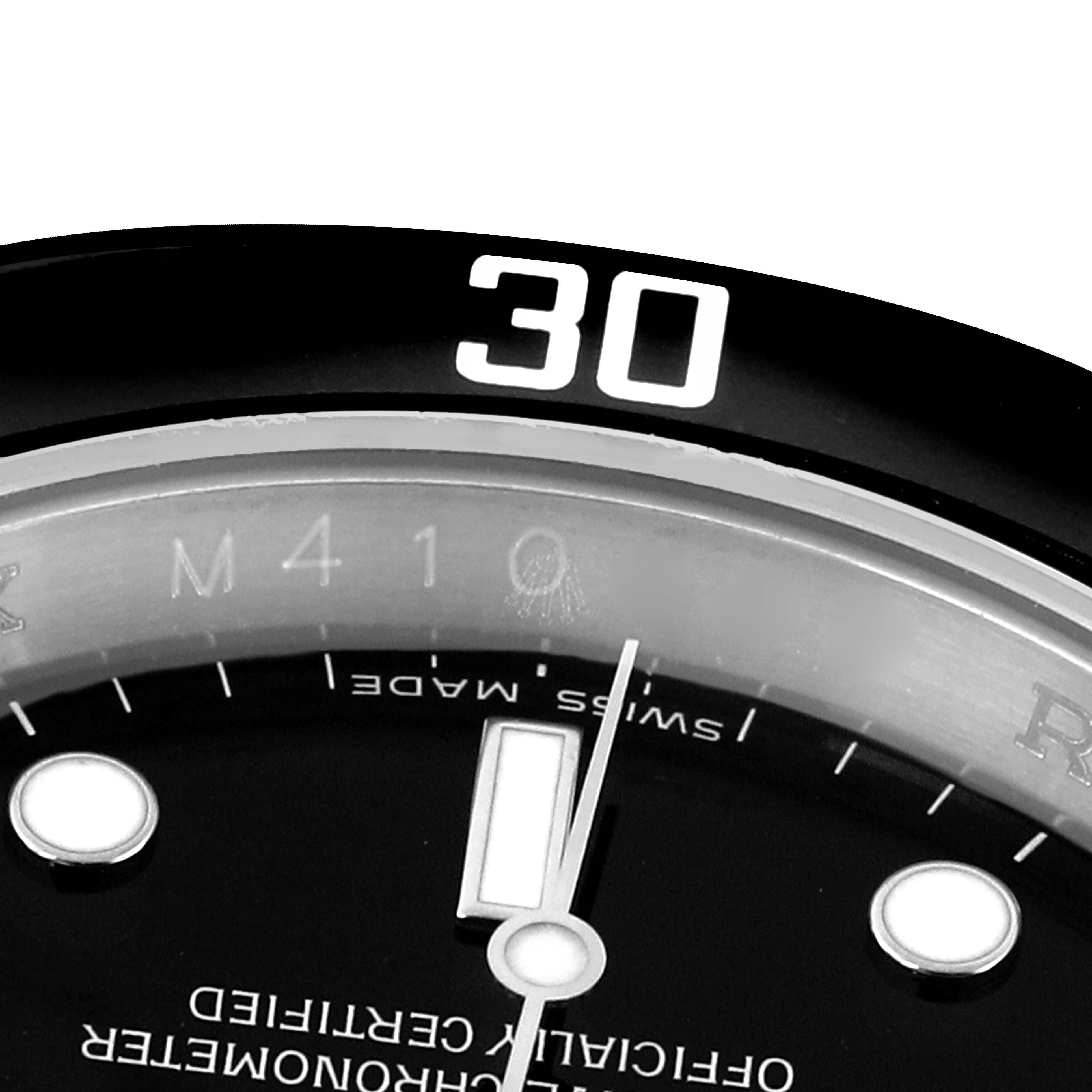 The image shows a close-up of the Rolex Submariner 16610 Men
s Stainless Steel Black Dial
s dial, focusing on the minute hand, bezel, and a portion of the indices.