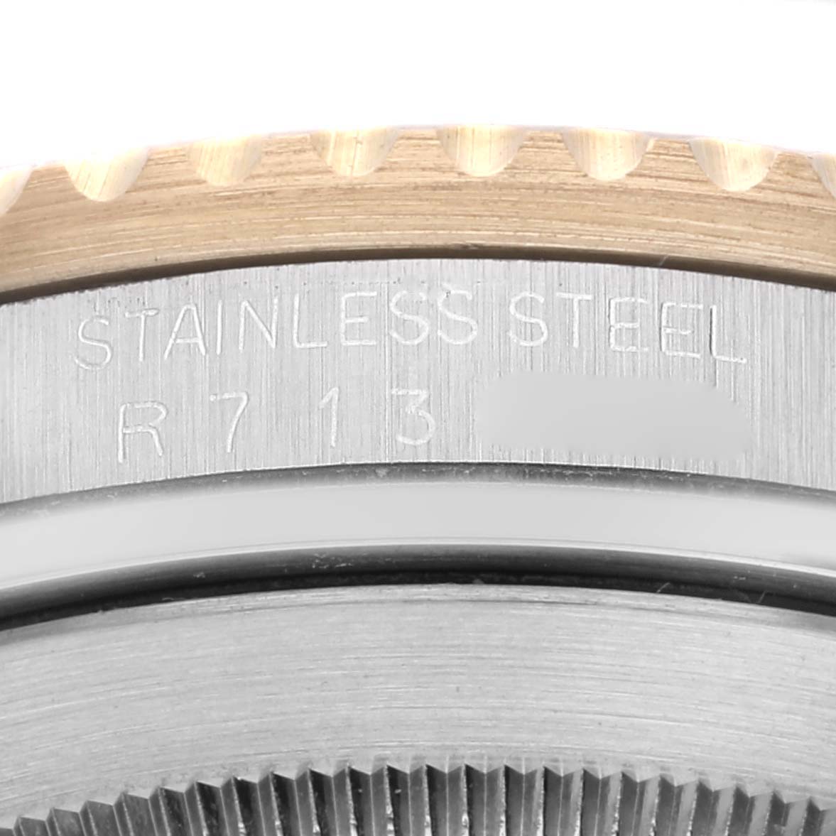 This close-up image shows the edge of the bezel and case of a Rolex Submariner 16613 Men's Steel and Gold (two tone) Black Dial 16613 Men's Steel and Gold (two tone) Black Dial watch, highlighting the "STAINLESS STEEL" engraving.