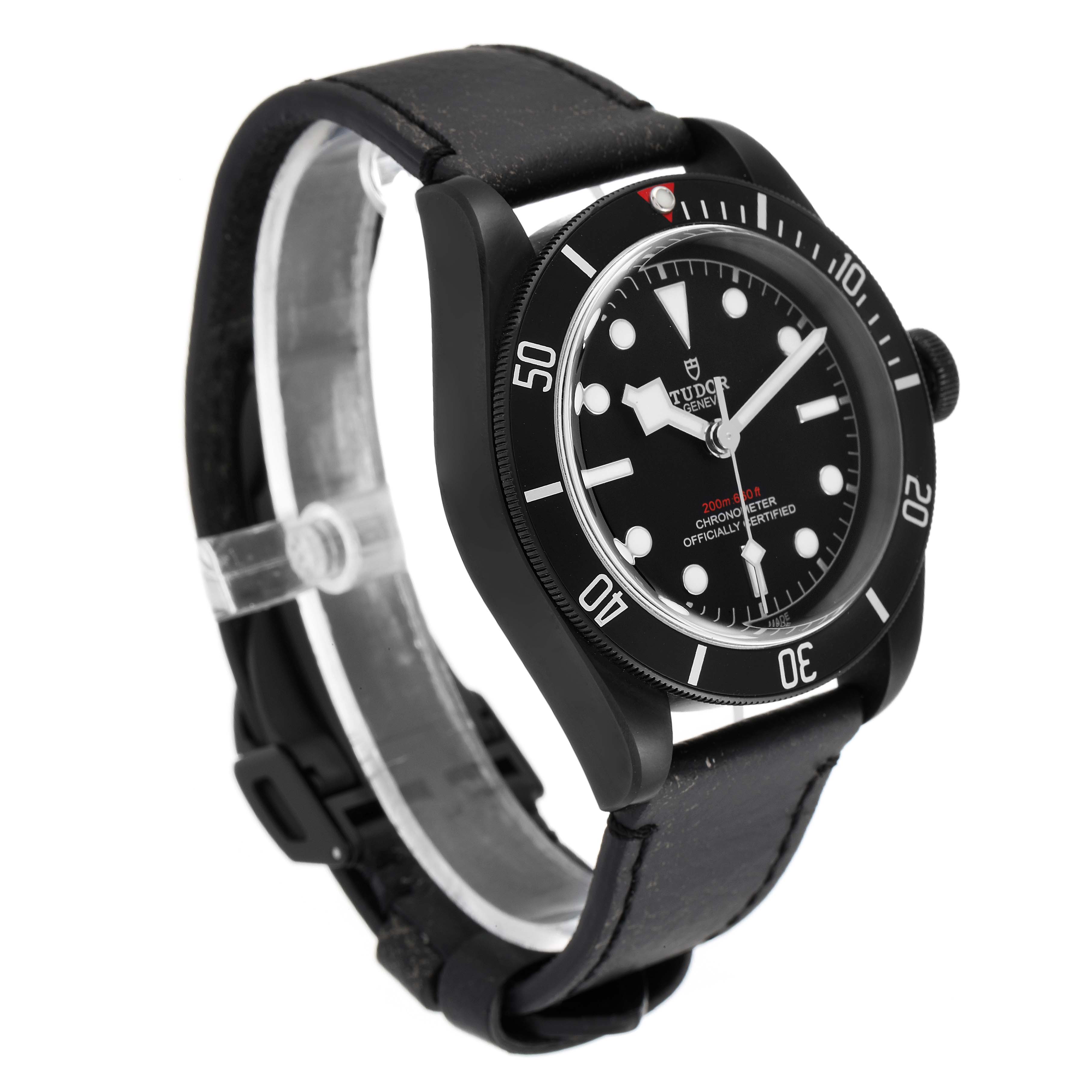 The image shows a side-angle view of a Tudor Heritage Black Bay 79230DK Men's Stainless Steel Black Dial 79230DK Men's Stainless Steel Black Dial watch, highlighting its black bezel, dial, and leather strap.