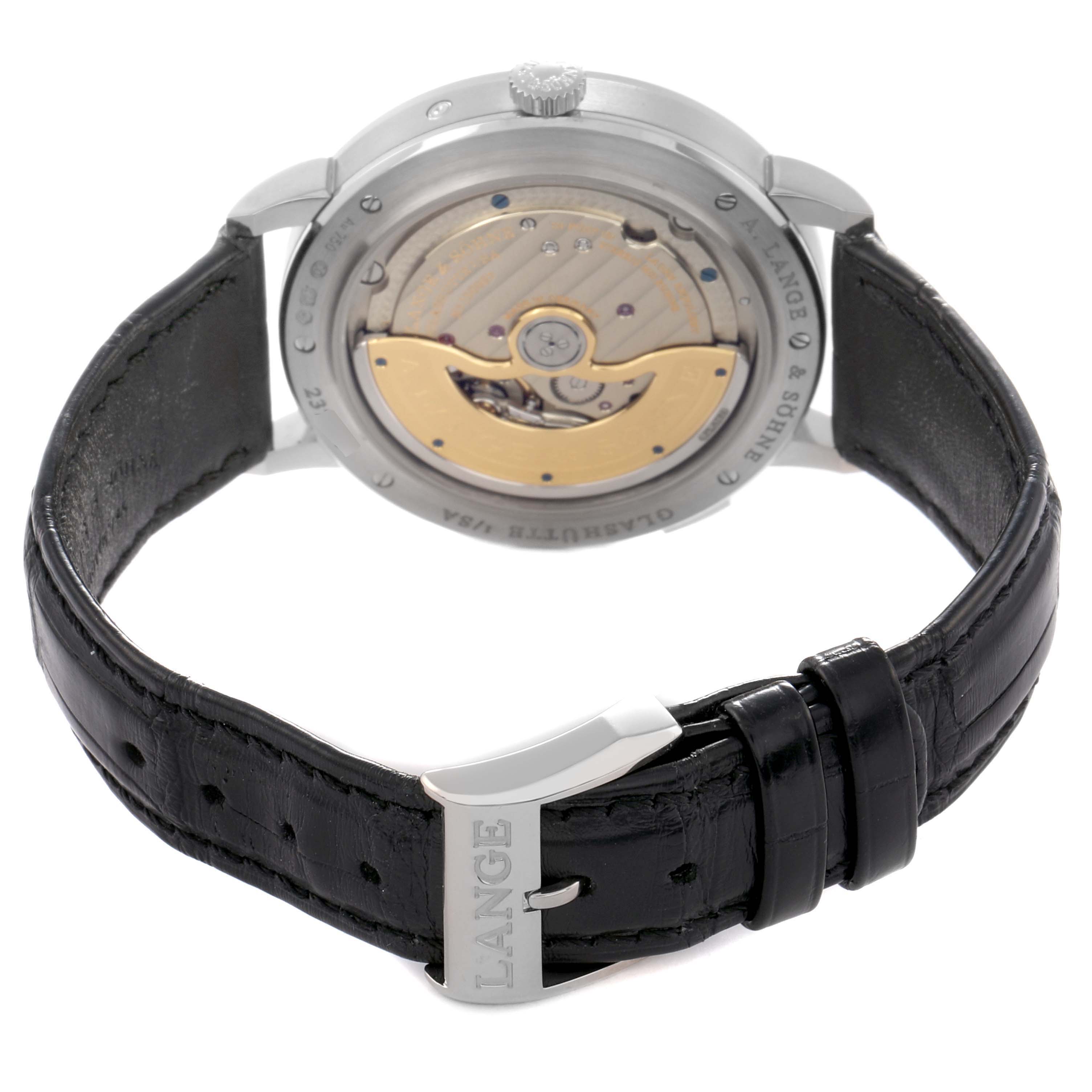 The image shows the back view of the A. Lange 
Sohne Saxonia 384.029 Men
s White Gold Black Dial, highlighting the movement and leather strap with a metal clasp.
