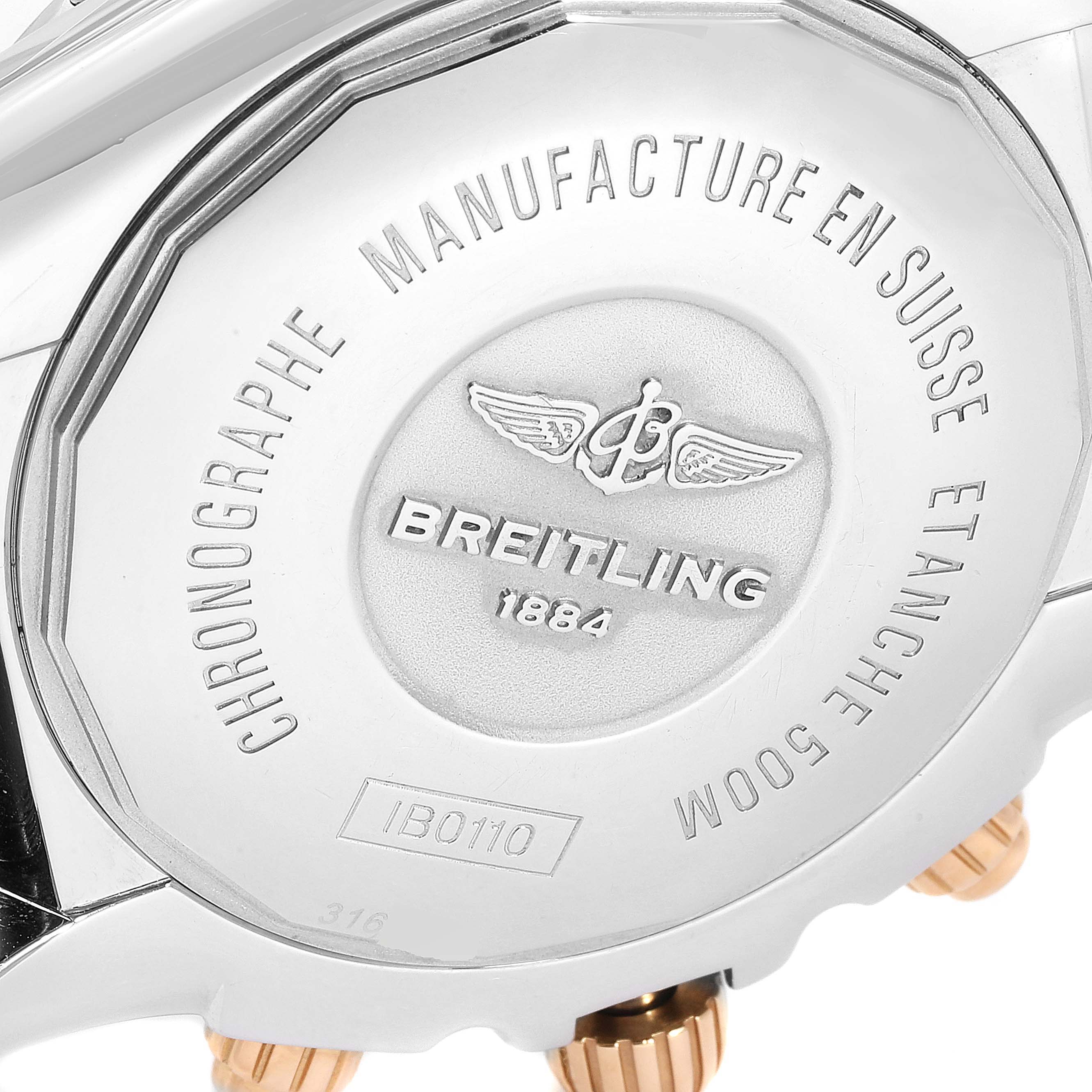 The image shows the case back of a Breitling Chronomat IB0110 Men's Steel and Gold (two tone) Blue Dial IB0110 Men's Steel and Gold (two tone) Blue Dial watch, highlighting engravings and two gold screws.
