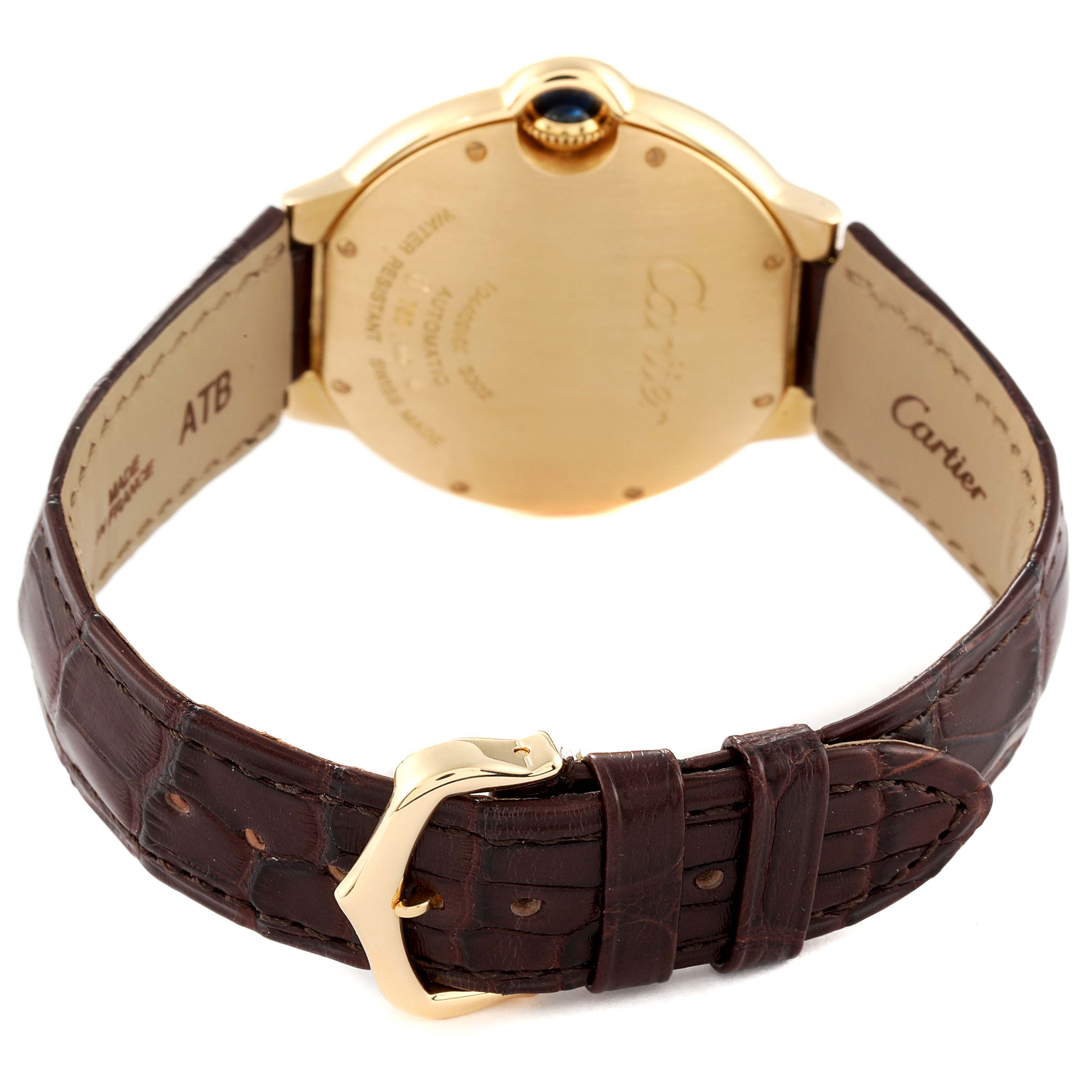 This image shows the back of a Cartier Ballon Bleu W6900356 Men's Yellow Gold Silver Dial W6900356 Men's Yellow Gold Silver Dial watch, highlighting its gold case, crown, and leather strap with a buckle.