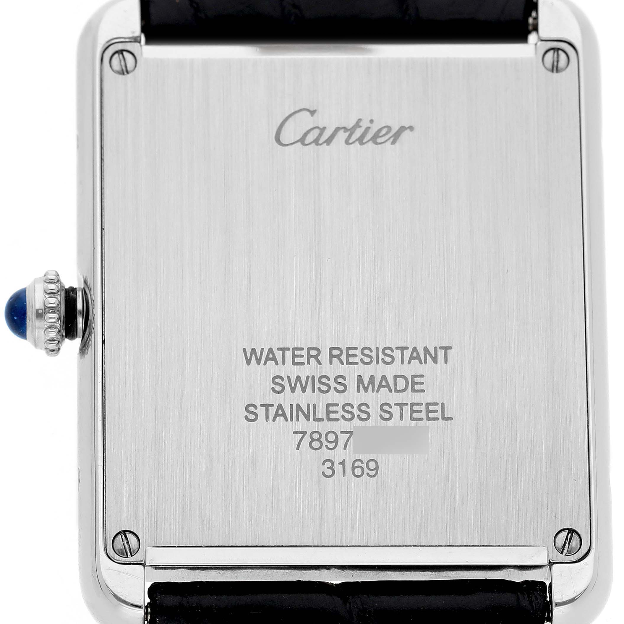The image shows the back of a Cartier Tank Solo W5200003 Men's Stainless Steel Silver Dial watch, highlighting the engraving and crown with a blue cabochon.