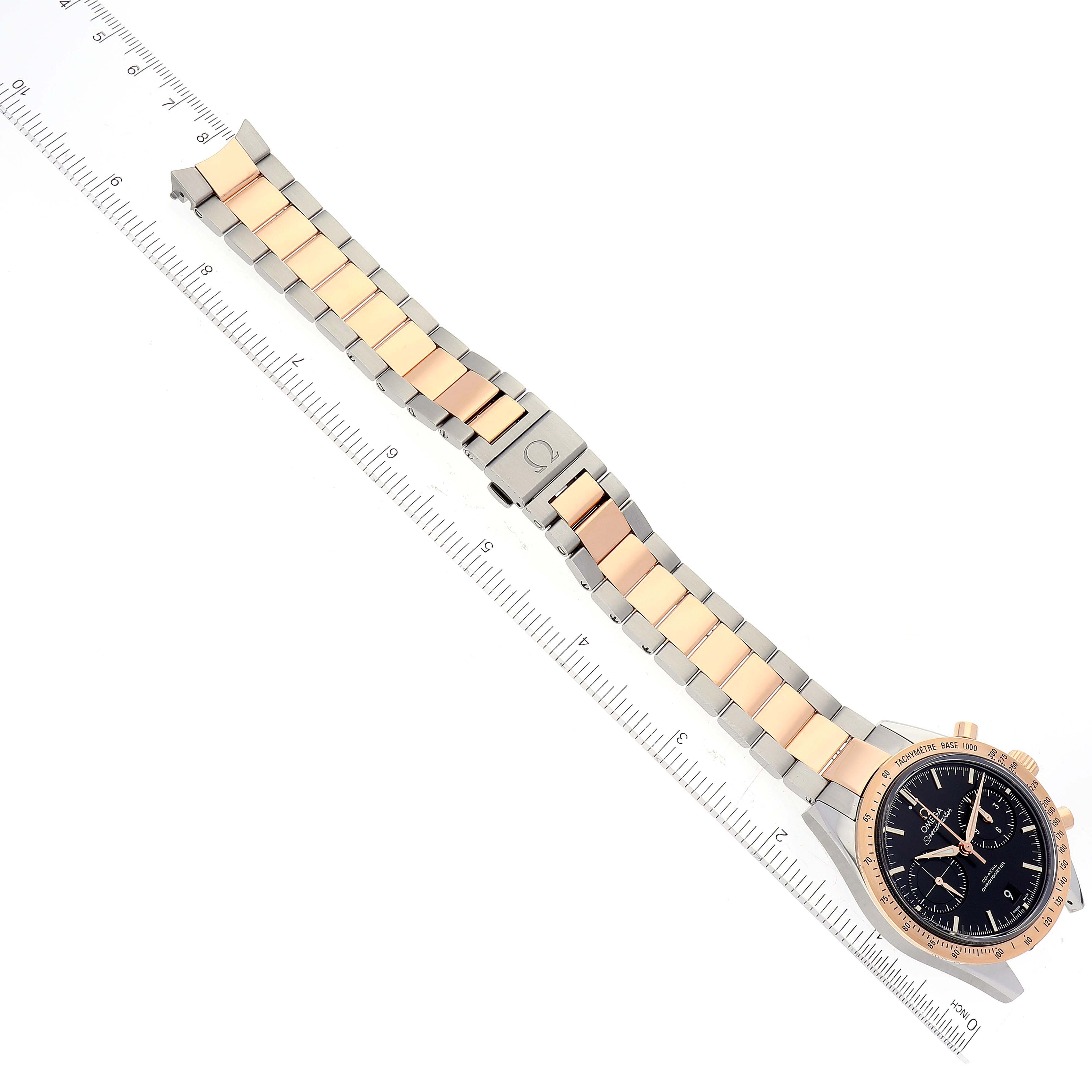 The Omega Speedmaster 331.20.42.51.01.002 Men's Steel and Gold (two tone) Black Dial 331.20.42.51.01.002 Men's Steel and Gold (two tone) Black Dial watch is shown from a top-down angle, displaying its case, dial, and full bracelet with a ruler.