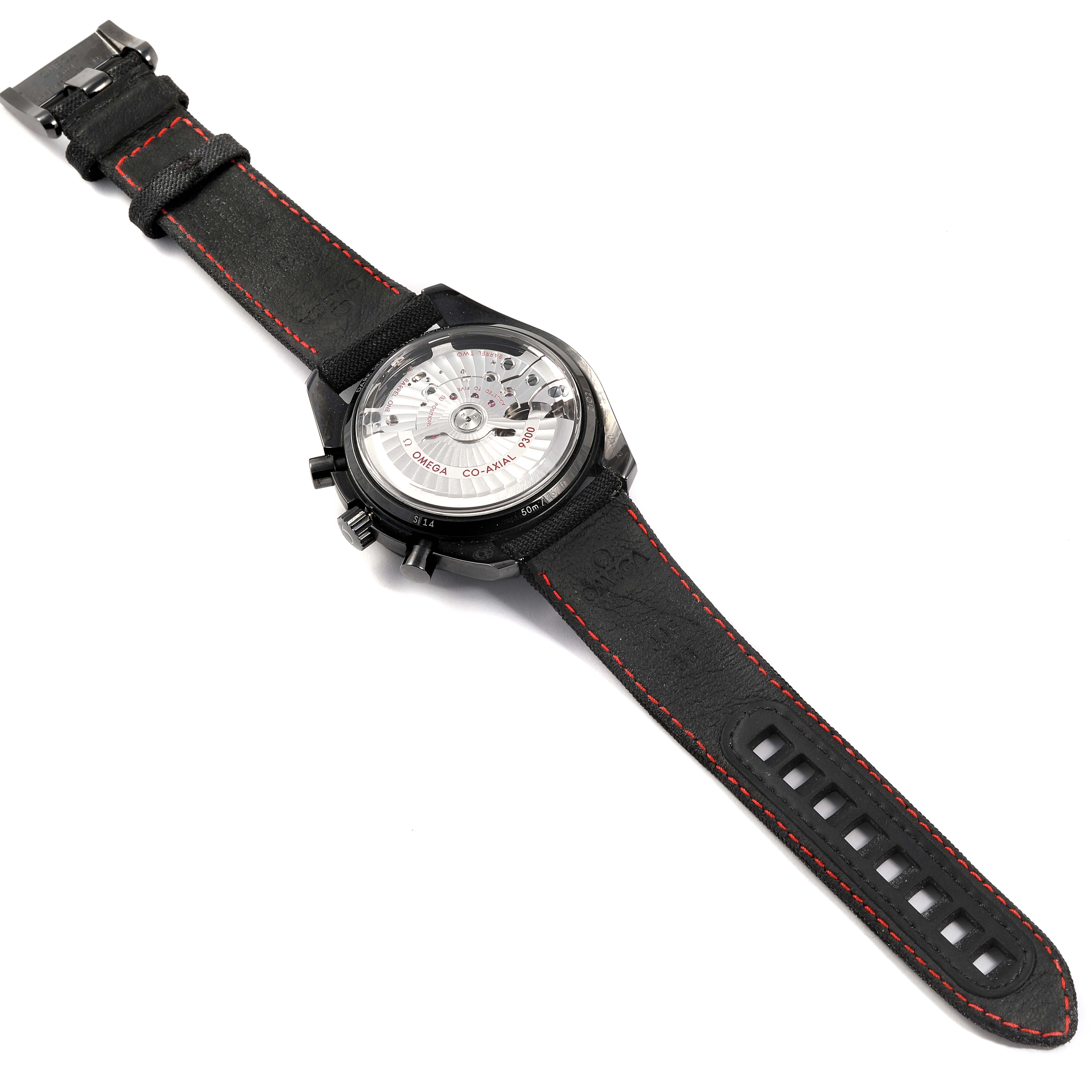 The image shows the back view of an Omega Speedmaster 311.92.44.51.01.003 Men's Titanium Black Dial 311.92.44.51.01.003 Men's Titanium Black Dial watch, highlighting the movement and leather strap with red stitching.