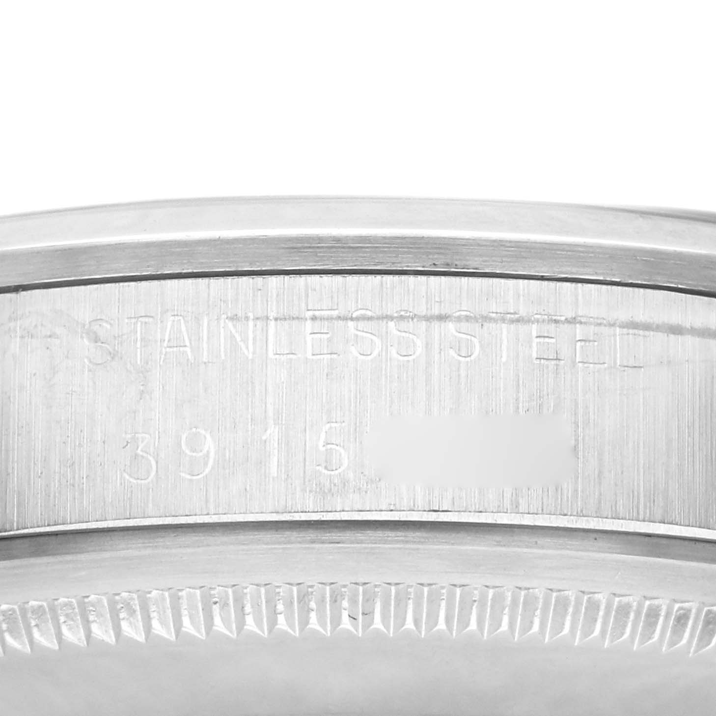 This image shows a close-up of the side of a Rolex Vintage Collection 1500 Men's Stainless Steel Blue Dial 1500 Men's Stainless Steel Blue Dial watch case, highlighting "STAINLESS STEEL" and serial number engravings.