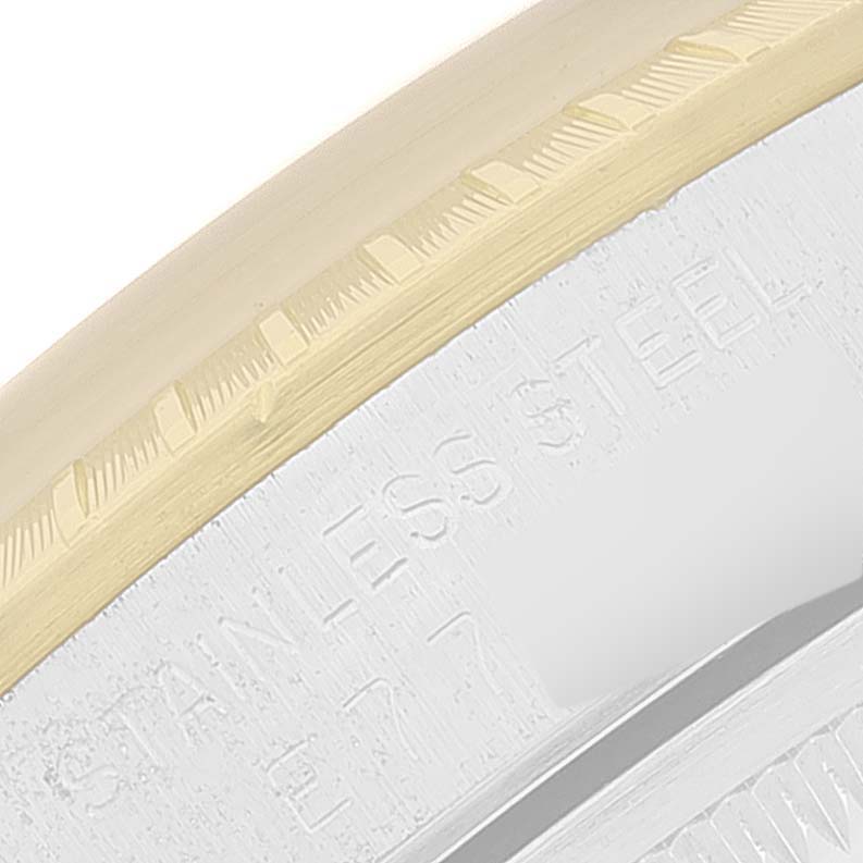 The close-up image shows the bezel and part of the case of a Rolex Date 15223 Men
s Steel and Gold (two tone) Champagne Dial 15223 Men
s Steel and Gold (two tone) Champagne Dial model, highlighting the "STAINLESS STEEL" engraving.