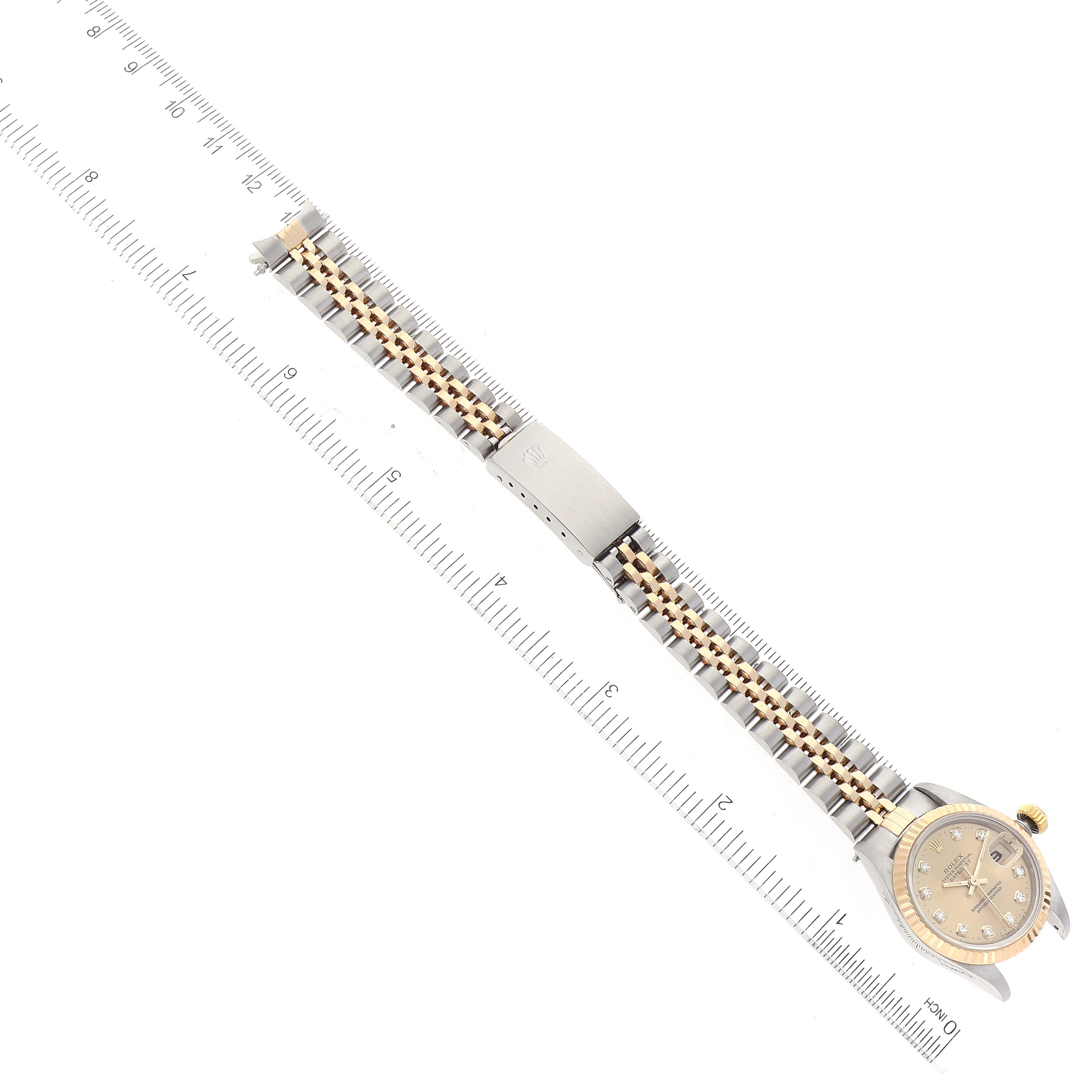 This image shows a top-down view of the Rolex Datejust 69173 Women's Steel and Gold (two tone) Champagne Dial 69173 Women's Steel and Gold (two tone) Champagne Dial watch, focusing on the dial, bracelet, and clasp, next to a ruler for scale.