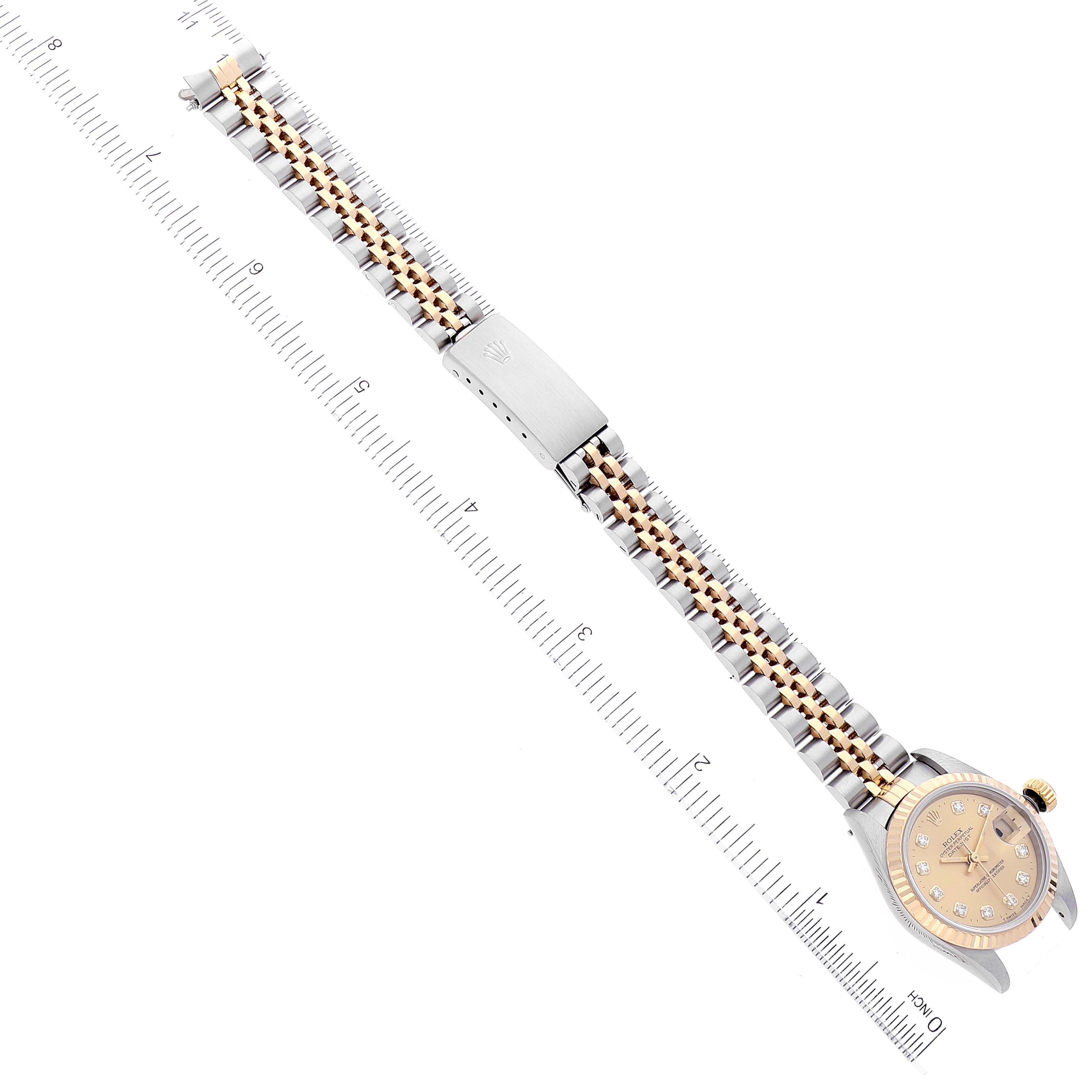 This image shows a Rolex Datejust 69173 Women's Steel and Gold (two tone) Champagne Dial 69173 Women's Steel and Gold (two tone) Champagne Dial watch from an overhead angle, displaying the face, bracelet, and clasp with rulers for scale.
