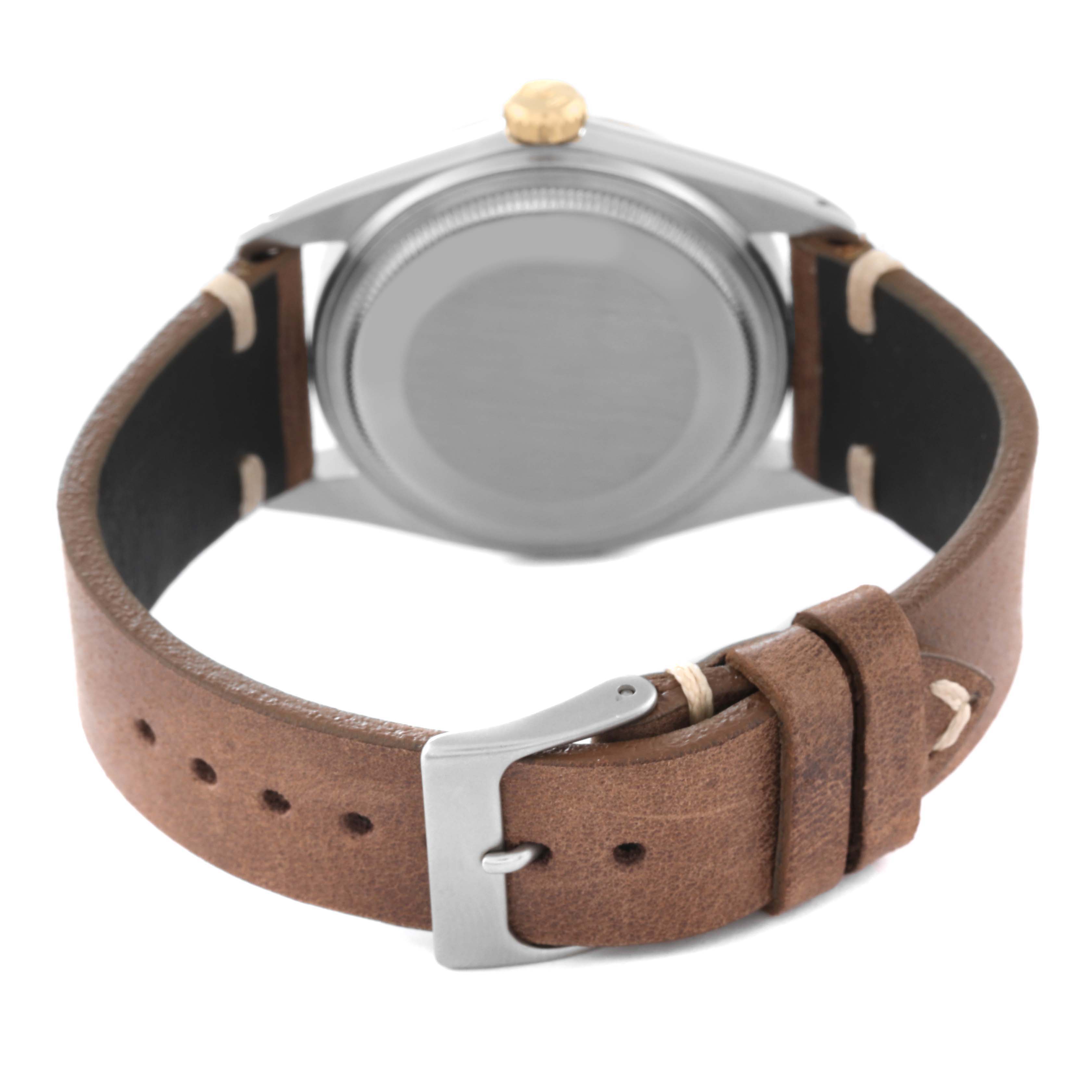 The image shows the back view of a Rolex Vintage Collection 16013 Men's Steel and Gold (two tone) Black Dial 16013 Men's Steel and Gold (two tone) Black Dial watch with a brown leather strap and a silver buckle.