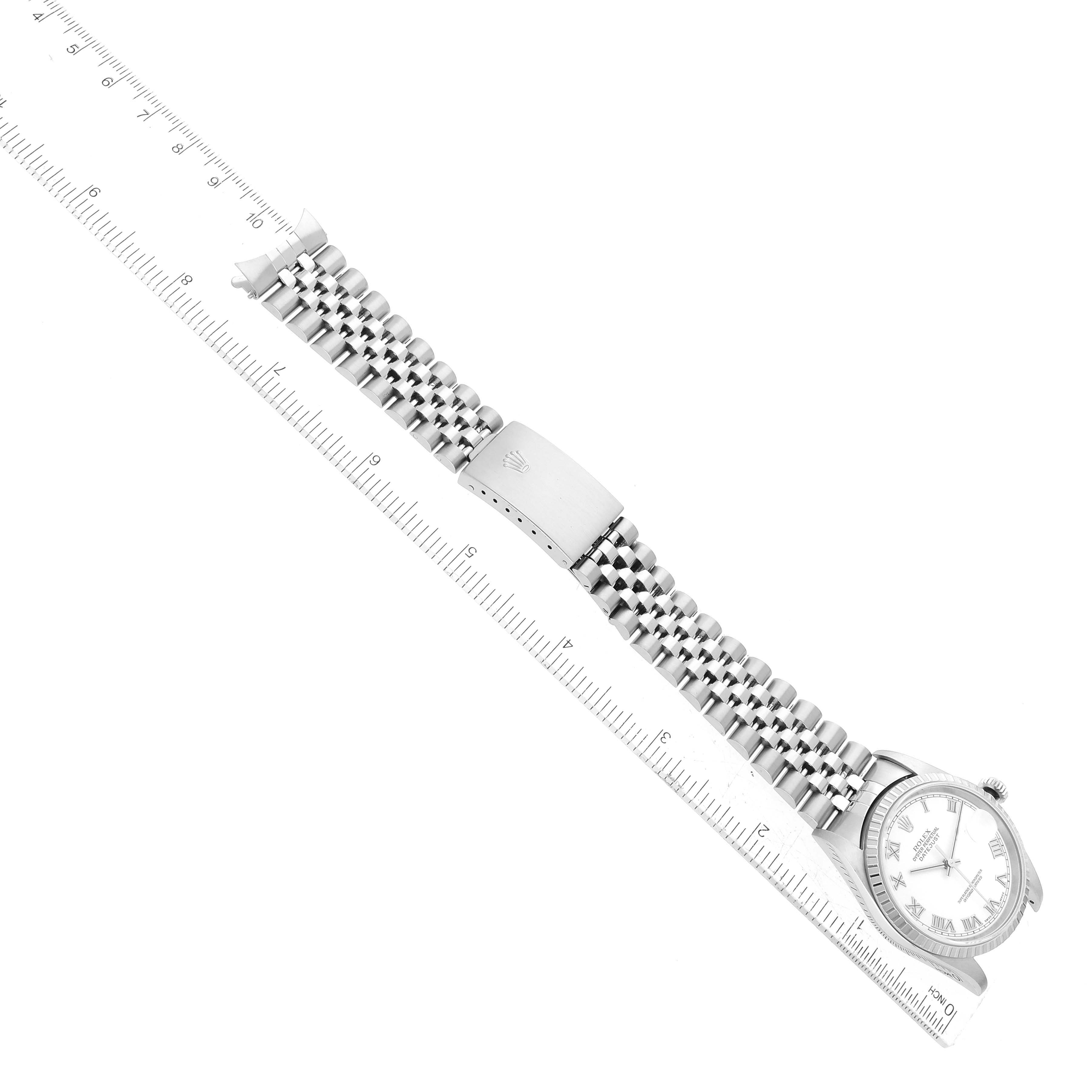 This image shows the Rolex Datejust 16220 Men's Stainless Steel White Dial 16220 Men's Stainless Steel White Dial watch positioned diagonally with an extended metal bracelet visible, alongside a ruler.