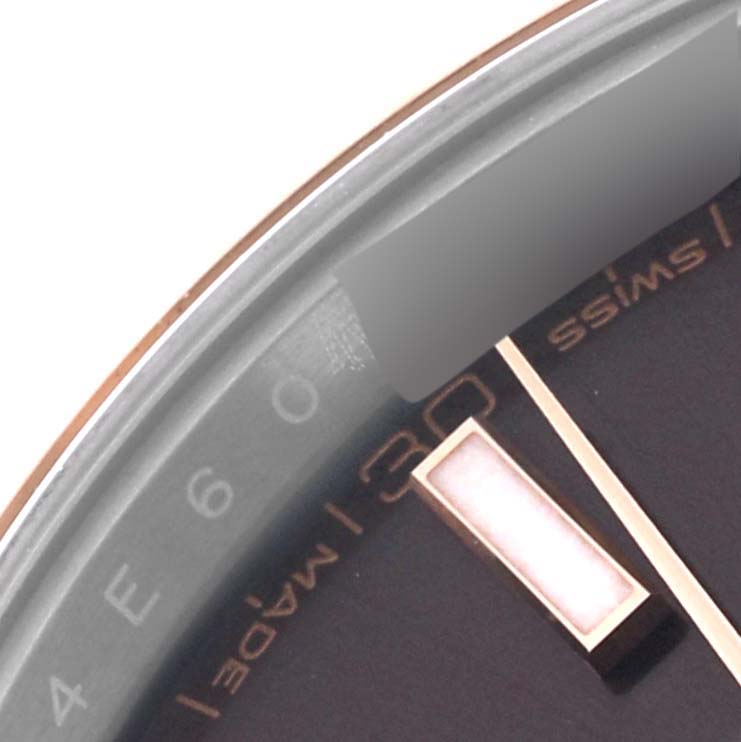 This close-up of the Rolex Datejust 41 126331 Men's Steel and Gold (two tone) Brown Dial 126331 Men's Steel and Gold (two tone) Brown Dial watch shows part of the watch face, hour marker, and the outer edge with "Swiss Made" text.