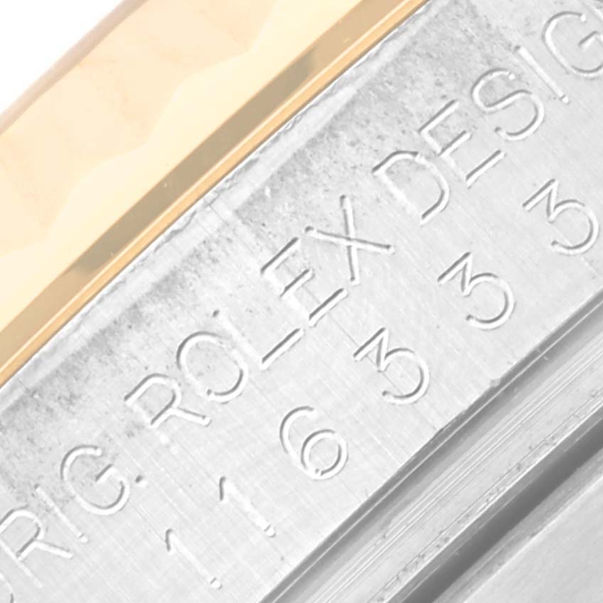 The image shows a close-up of the engravings on the bezel of a Rolex Datejust 41 116333 Men's Steel and Gold (two tone) Grey Dial 116333 Men's Steel and Gold (two tone) Grey Dial, highlighting part of the bezel and the case.
