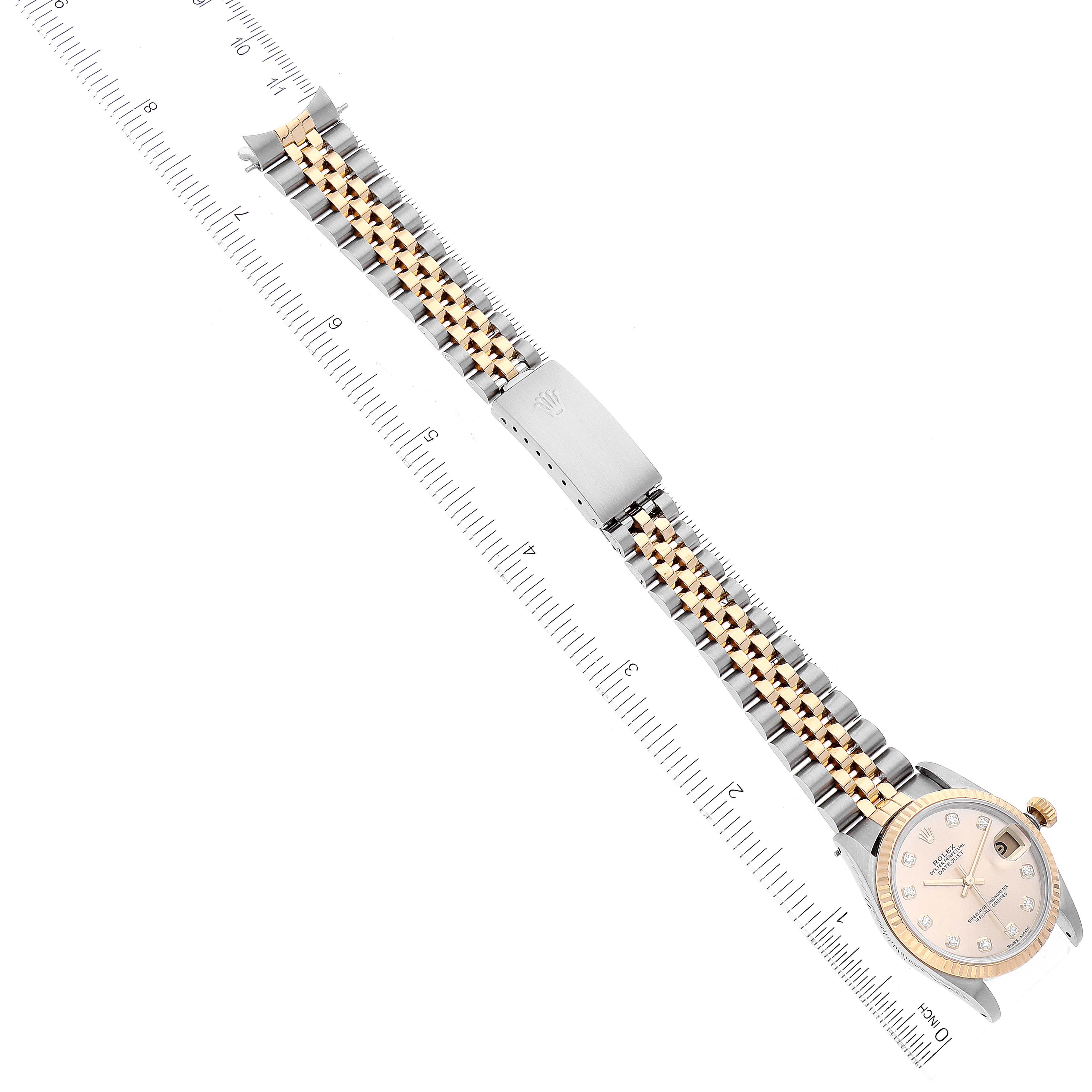 The image shows a laid-flat view of a Rolex Mid-Size 68273 Women
s Steel and Gold (two tone) Champagne Dial 68273 Women
s Steel and Gold (two tone) Champagne Dial watch with its band and clasp, alongside a ruler for scale.
