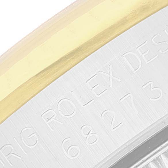 This close-up shows the side of a Rolex Mid-Size 68273 Women
s Steel and Gold (two tone) Champagne Dial 68273 Women
s Steel and Gold (two tone) Champagne Dial model, featuring part of the bezel and engraved lettering.