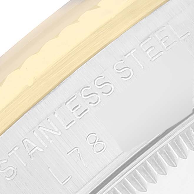 This close-up image shows the side view of a Rolex Mid-Size 68273 Women
s Steel and Gold (two tone) Champagne Dial 68273 Women
s Steel and Gold (two tone) Champagne Dial model watch
s bezel, focusing on the stainless steel and gold detailing.