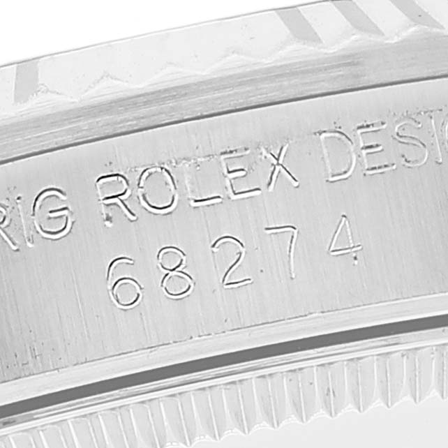 This image shows a close-up of the engraved serial number and brand name on the case of a Mid-Size Rolex watch.