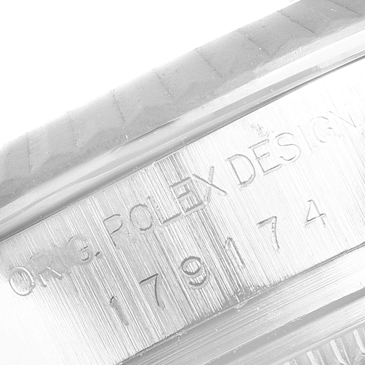 The image shows a close-up of the side engraving on the bezel of a Rolex Datejust 179174 Women's Stainless Steel Black Dial 179174 Women's Stainless Steel Black Dial watch.