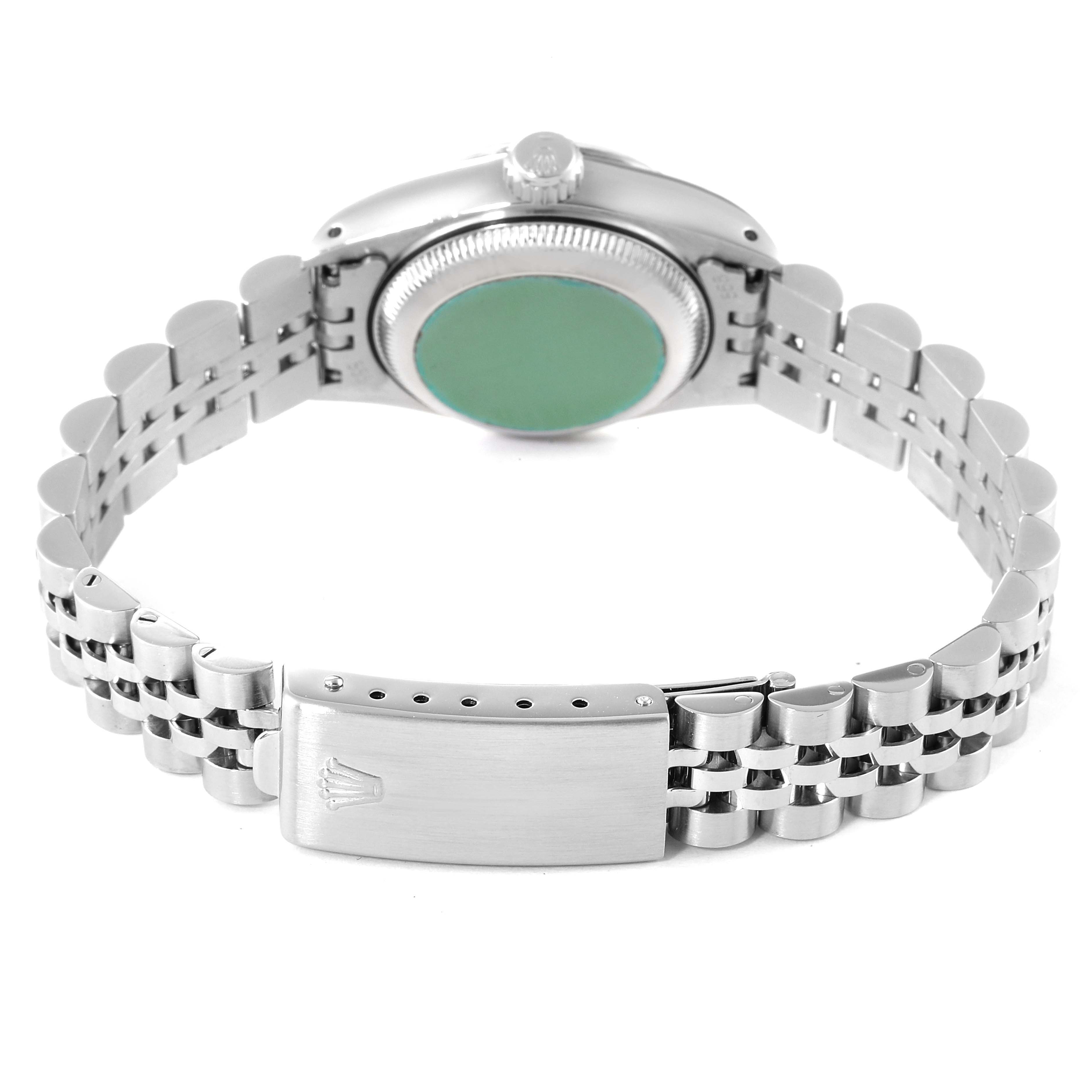 The image shows the back view of a Rolex Datejust 69174 Women's Stainless Steel Silver Dial 69174 Women's Stainless Steel Silver Dial watch, highlighting its green hologram sticker and metal bracelet with the clasp open.