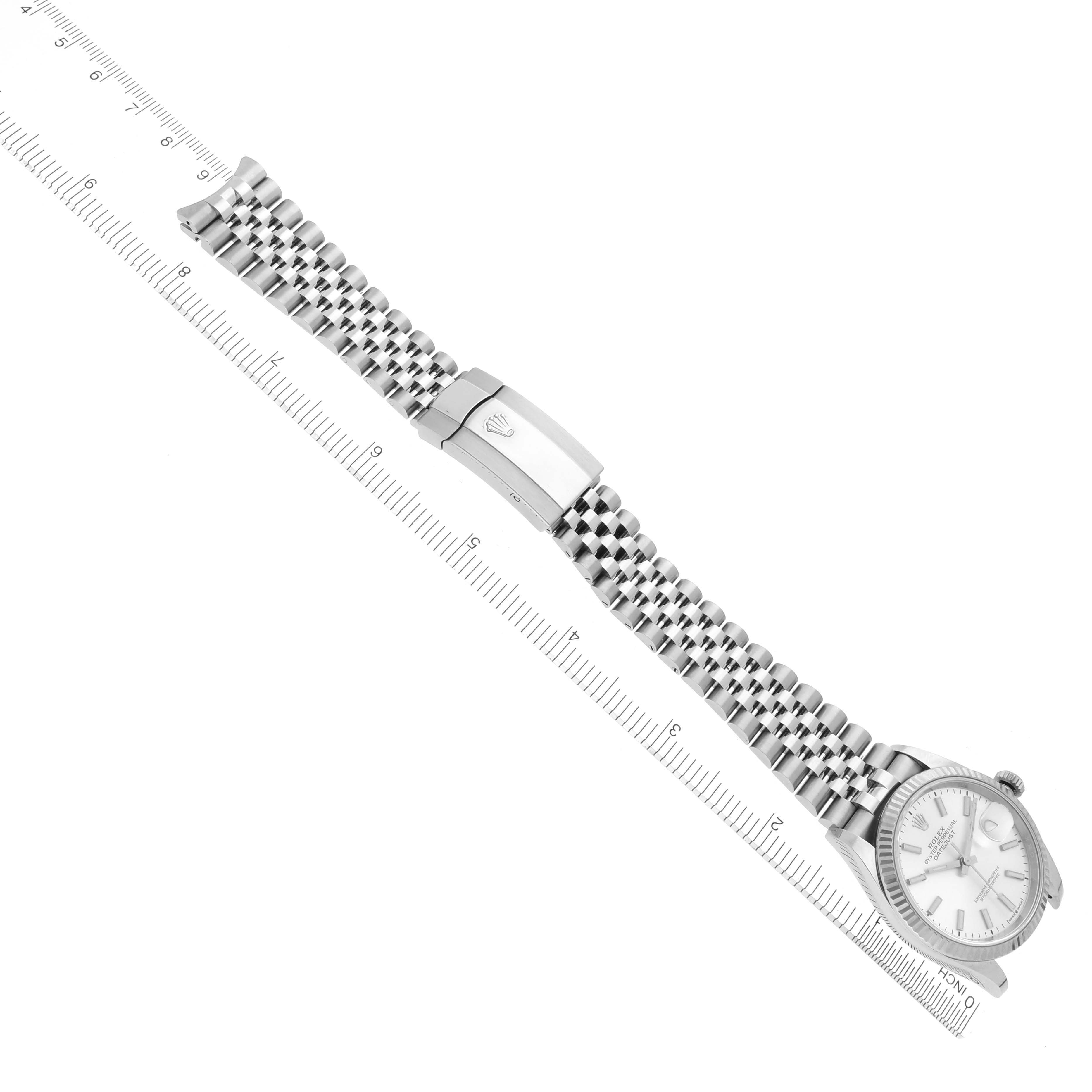 The image shows a Rolex Datejust 126234 Men's Stainless Steel Silver Dial watch at an oblique angle, highlighting its bracelet and clasp alongside a ruler for scale.