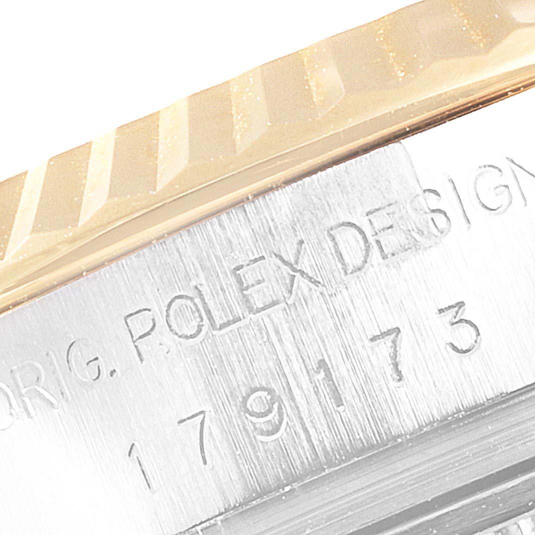 This image shows a close-up view of the Rolex Datejust 179173 Women's Steel and Gold (two tone) Mother of Pearl Dial 179173 Women's Steel and Gold (two tone) Mother of Pearl Dial watch bezel and part of the case with engraved model details.