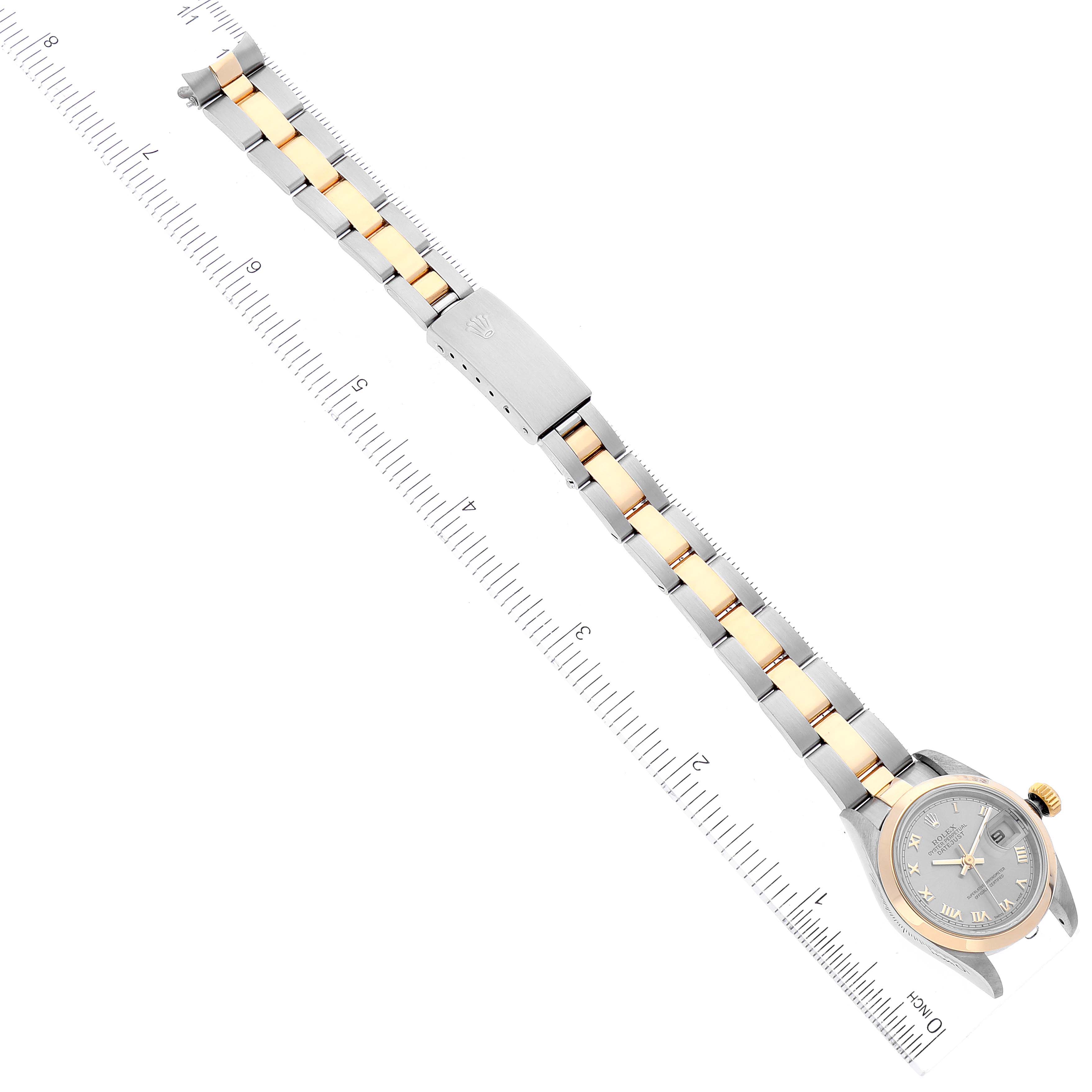 This image shows the entire Rolex Datejust 69163 Women
s Steel and Gold (two tone) Grey Dial 69163 Women
s Steel and Gold (two tone) Grey Dial watch laid flat, showcasing its band and face alongside a measurement ruler.