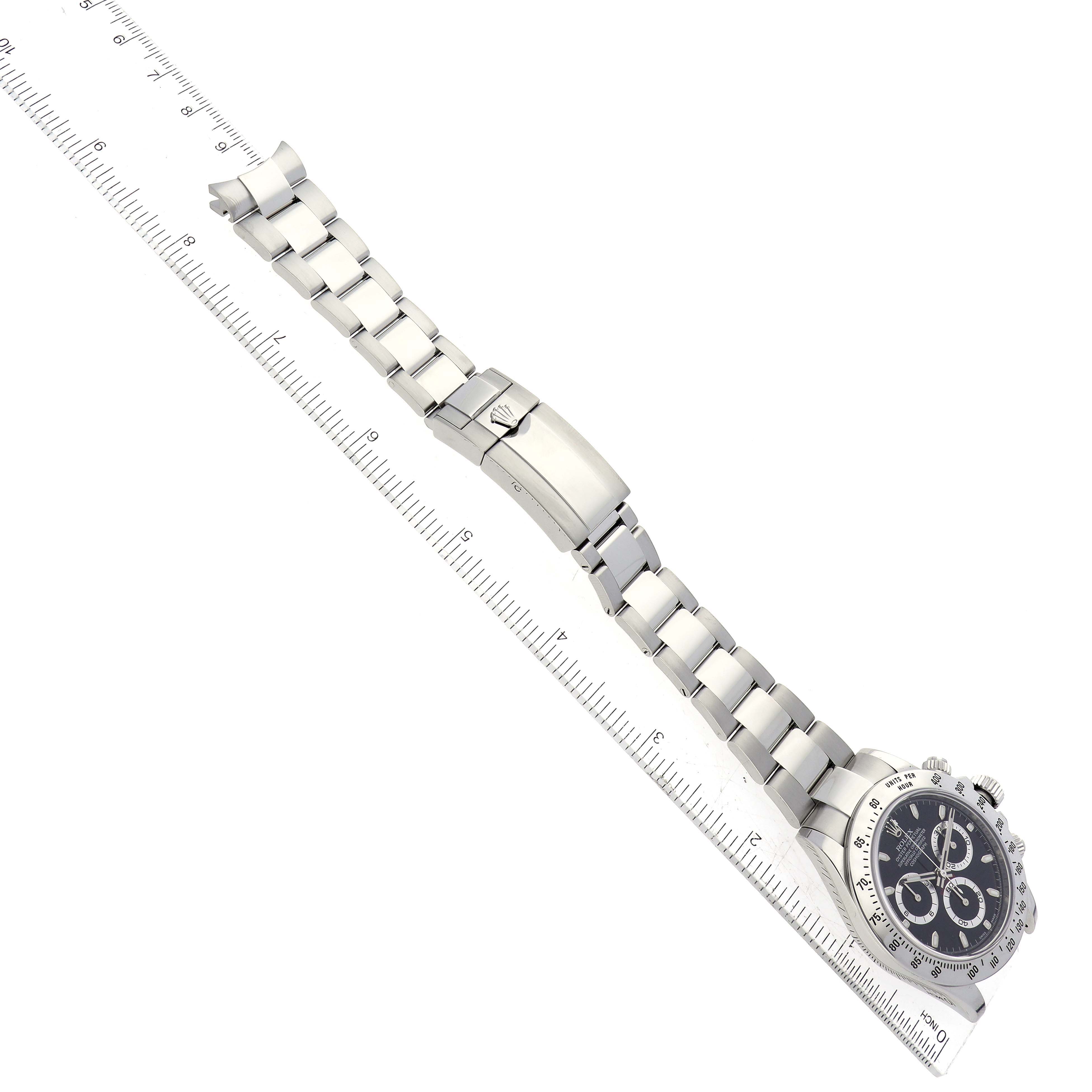 The image shows a top view of a Rolex Daytona 116520 Men's Stainless Steel Black Dial 116520 Men's Stainless Steel Black Dial watch, highlighting its bracelet, clasp, and partially visible dial next to a ruler.