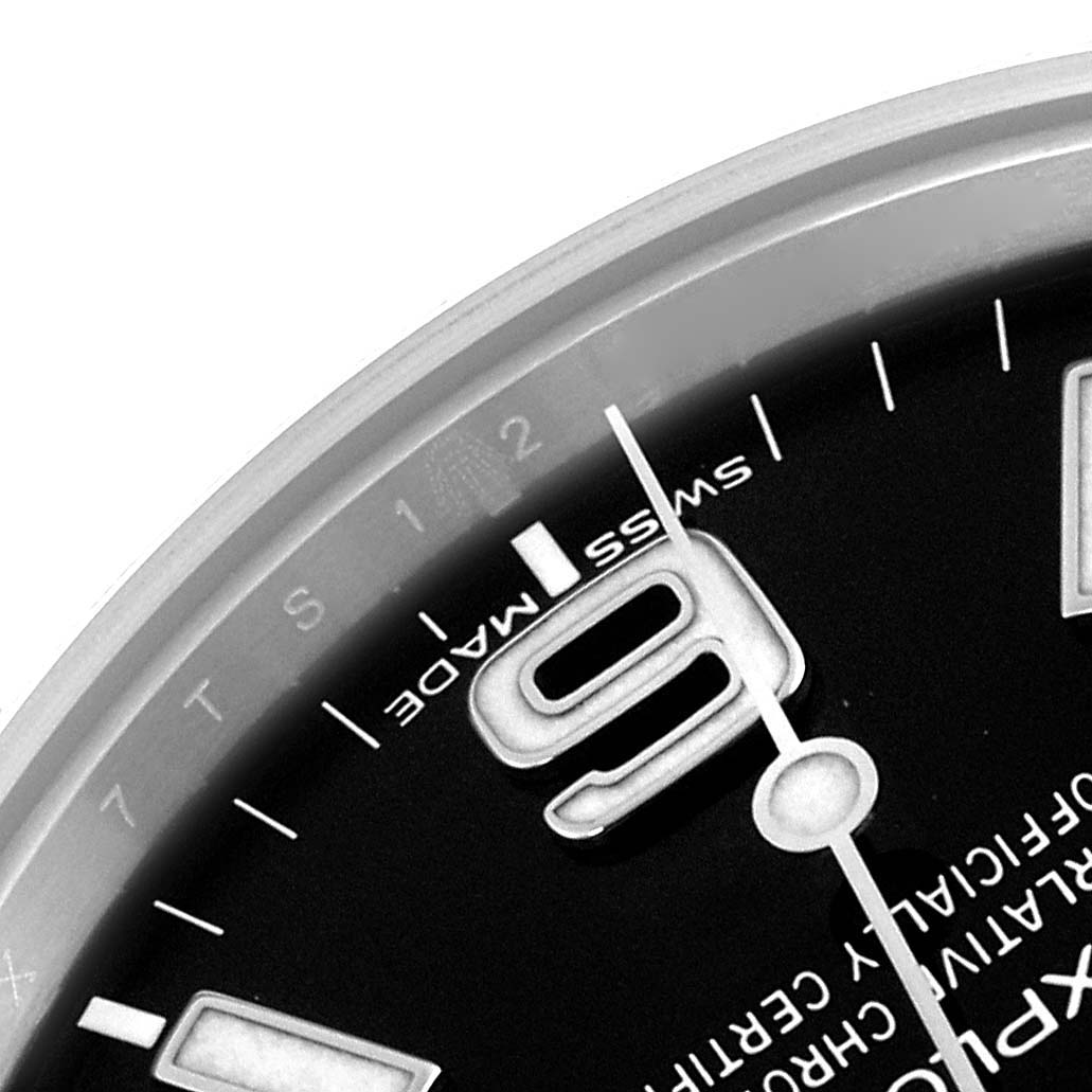 The image shows a close-up of the Rolex Explorer 214270 Men's Stainless Steel Black Dial watch face focusing on the numeral "9" and part of the minute track.