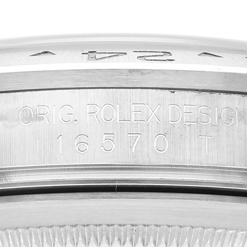 The image shows a detailed close-up of the side of a Rolex Explorer 16570 Men's Stainless Steel Black Dial 16570 Men's Stainless Steel Black Dial model watch, focusing on the engraved "ORIG. ROLEX DESIGN" and model number "16570 T."