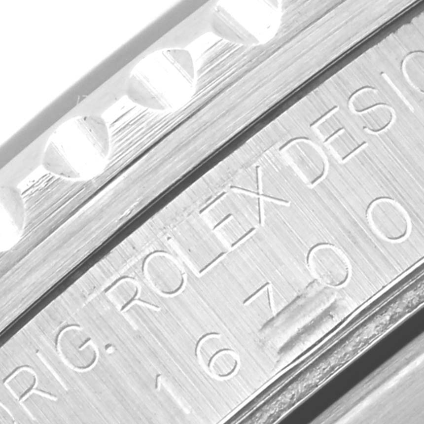 This close-up of a Rolex GMT-Master 16700 Men's Stainless Steel Black Dial 16700 Men's Stainless Steel Black Dial shows the engraved model number and part of the bezel.