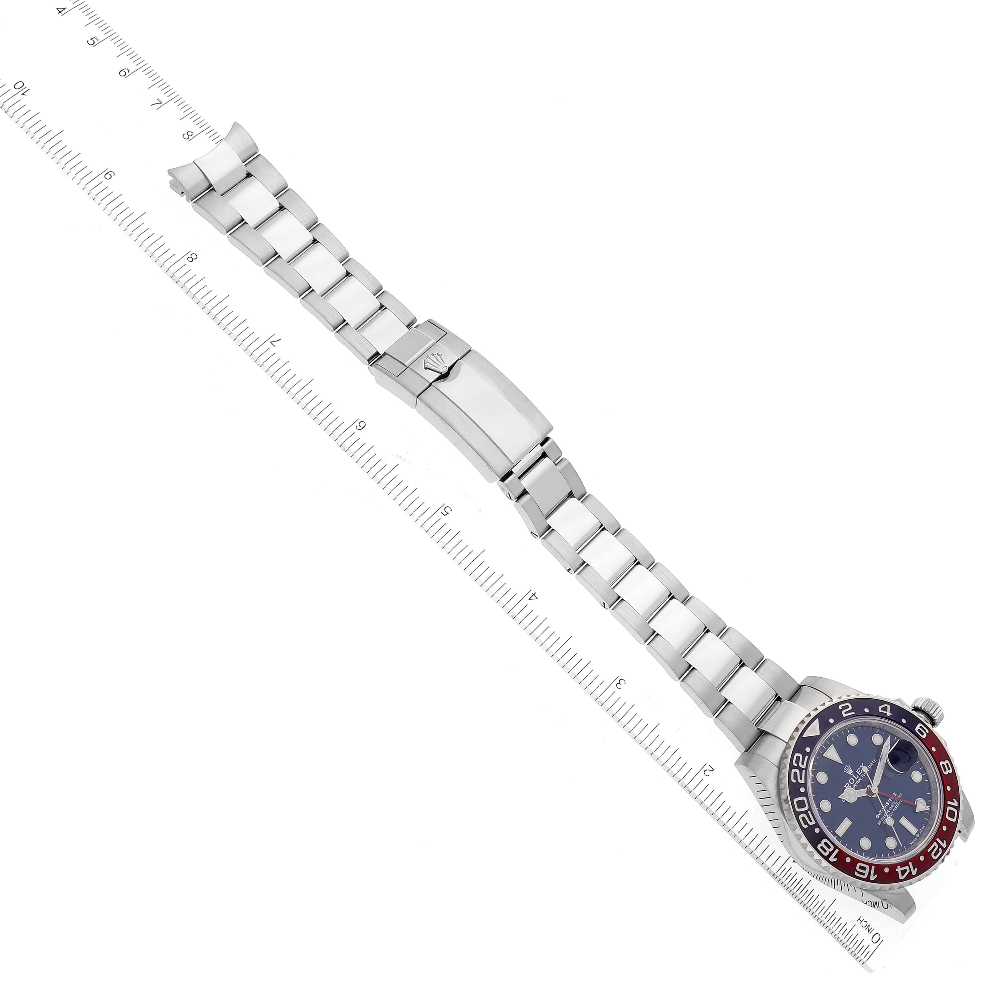 The image shows a top-down view of a Rolex GMT-Master 126719 Men's White Gold Blue Dial 126719 Men's White Gold Blue Dial watch with a ruler for scale, displaying the watch face and stainless steel bracelet.