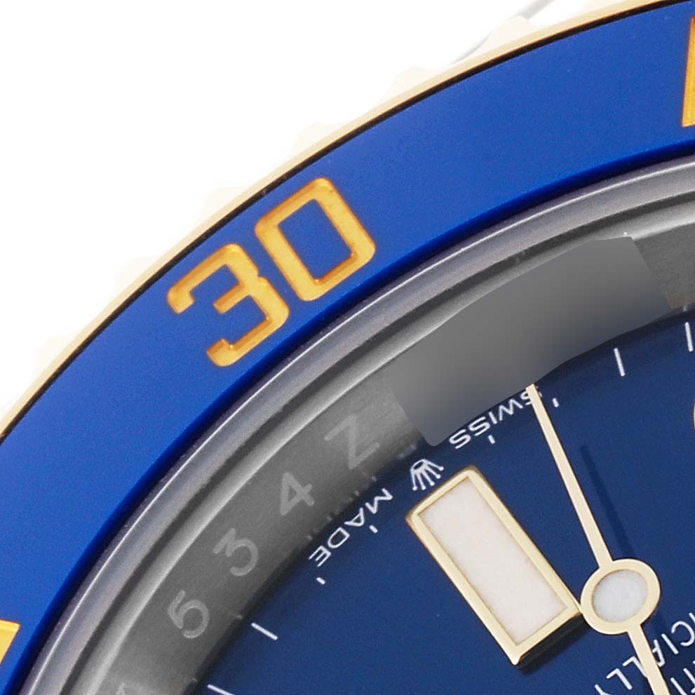 This image shows a close-up of the bezel, dial, and part of the minute hand of the Rolex Submariner 126613 Men's Steel and Gold (two tone) Blue Dial 126613 Men's Steel and Gold (two tone) Blue Dial watch.