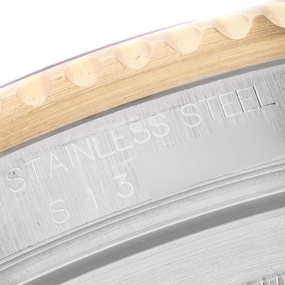 This image shows a close-up of the bezel edge and part of the case back with engraving on a Rolex Submariner 16613 Men's Steel and Gold (two tone) Blue Dial 16613 Men's Steel and Gold (two tone) Blue Dial.