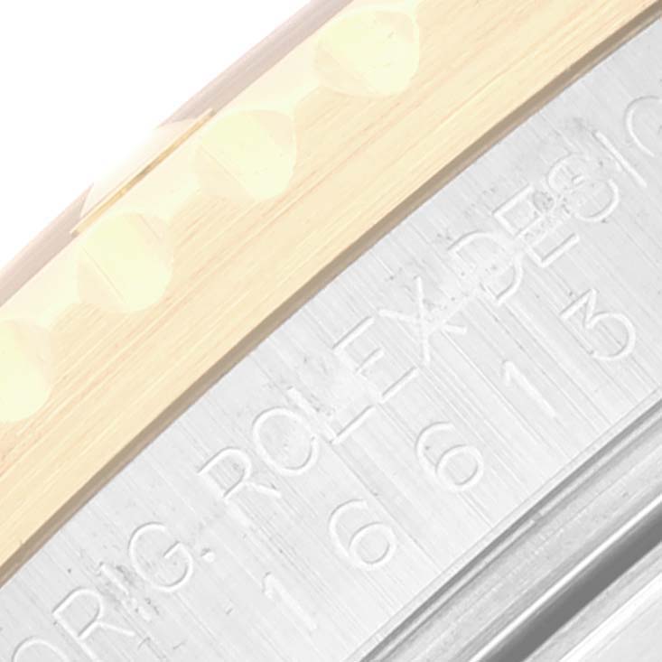 This close-up image of a Rolex Submariner 16613 Men's Steel and Gold (two tone) Black Dial 16613 Men's Steel and Gold (two tone) Black Dial shows part of the bezel and the engraved side of the case with model number.
