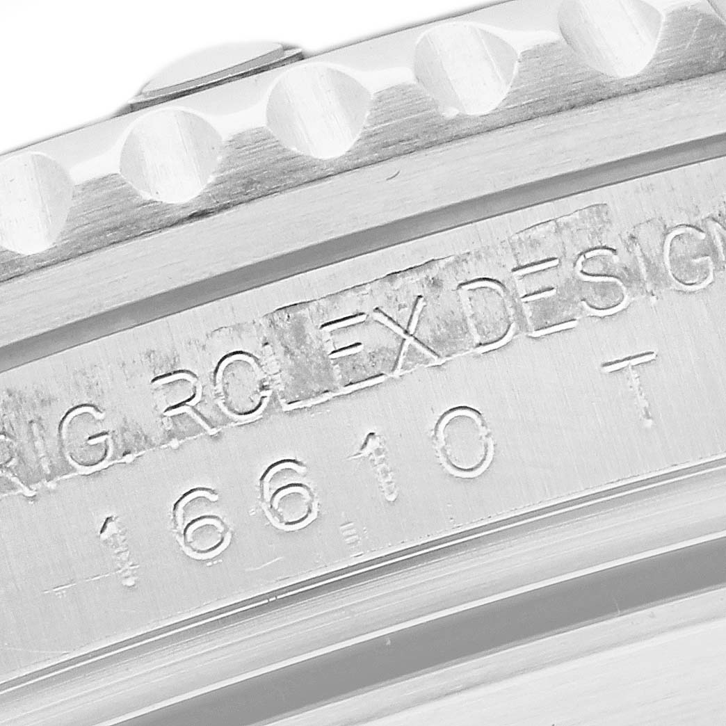 The image shows a close-up of the bezel and engraved serial number of a Rolex Submariner 16610 Men's Stainless Steel Black Dial 16610 Men's Stainless Steel Black Dial watch.