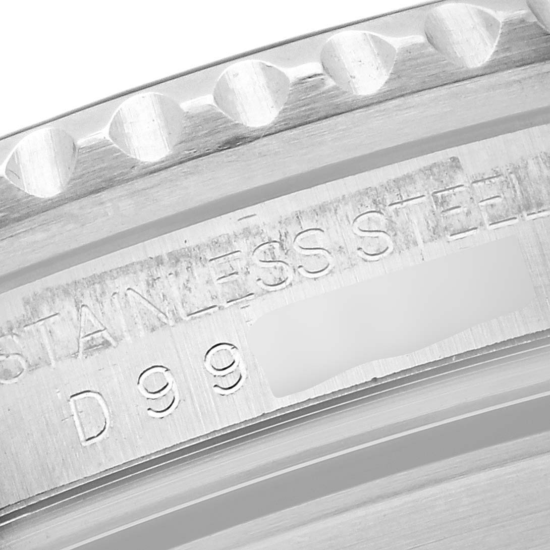 This is a close-up image of the edge of a Rolex Submariner 16610 Men's Stainless Steel Black Dial 16610 Men's Stainless Steel Black Dial watch case, showing "STAINLESS STEEL" engraving and part of the serial number.