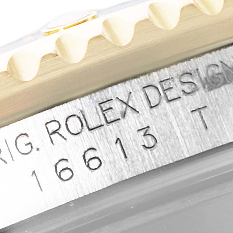 The image shows a close-up of the bezel and engraved case side of the Rolex Submariner 16613 Men's Steel and Gold (two tone) Silver Dial.