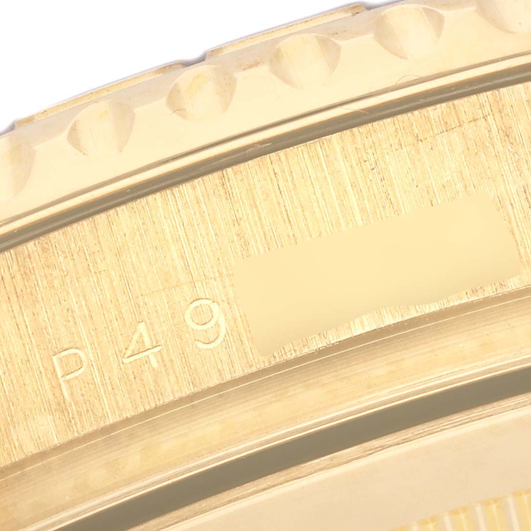 The image shows a close-up of the bezel and part of the case back of a Rolex Yacht-Master 16628 Men's Yellow Gold White Dial 16628 Men's Yellow Gold White Dial watch featuring some engraved markings.