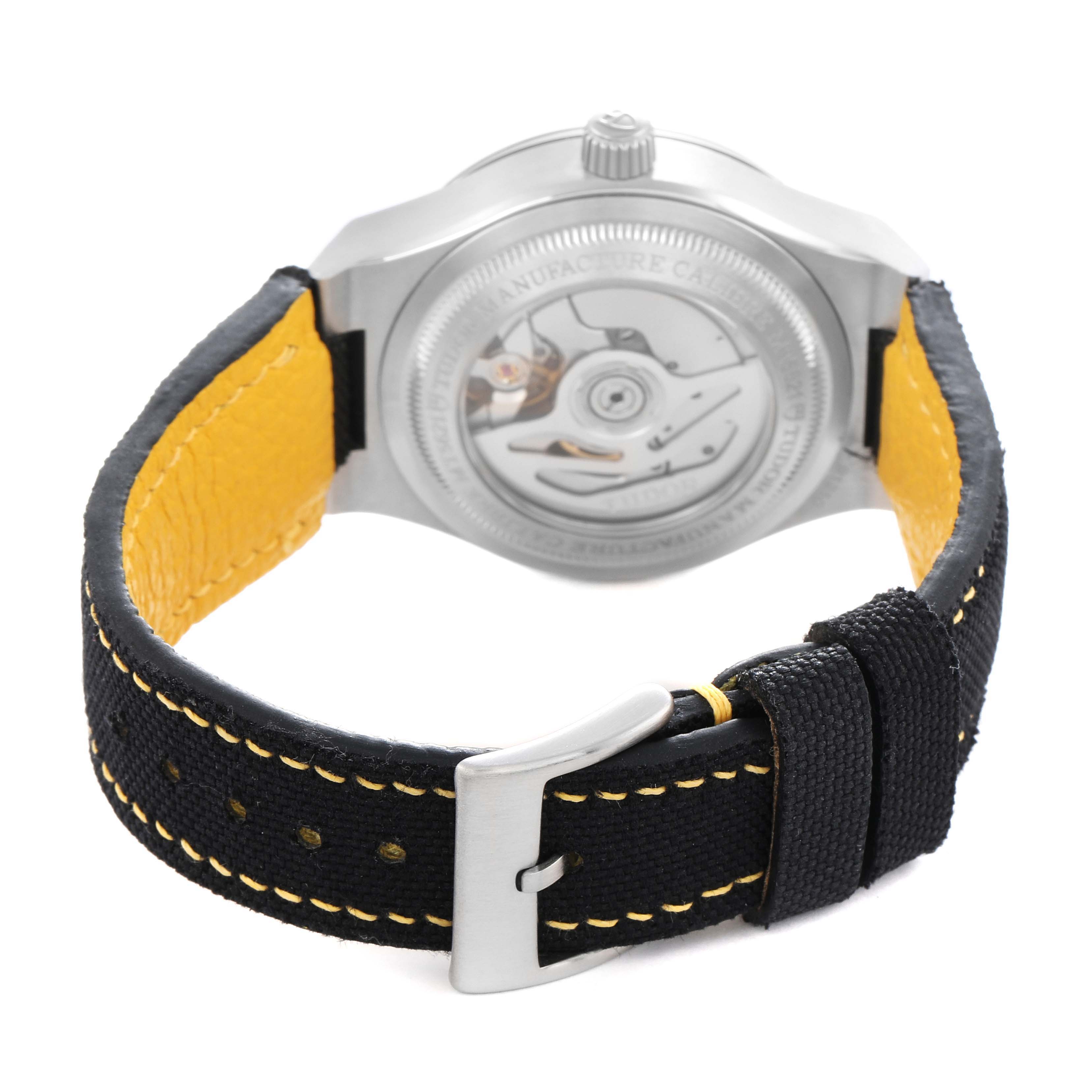 The image shows a Tudor Pelagos 91210N Men
s Stainless Steel Black Dial watch from the back, highlighting the open case back and fabric strap with yellow lining.