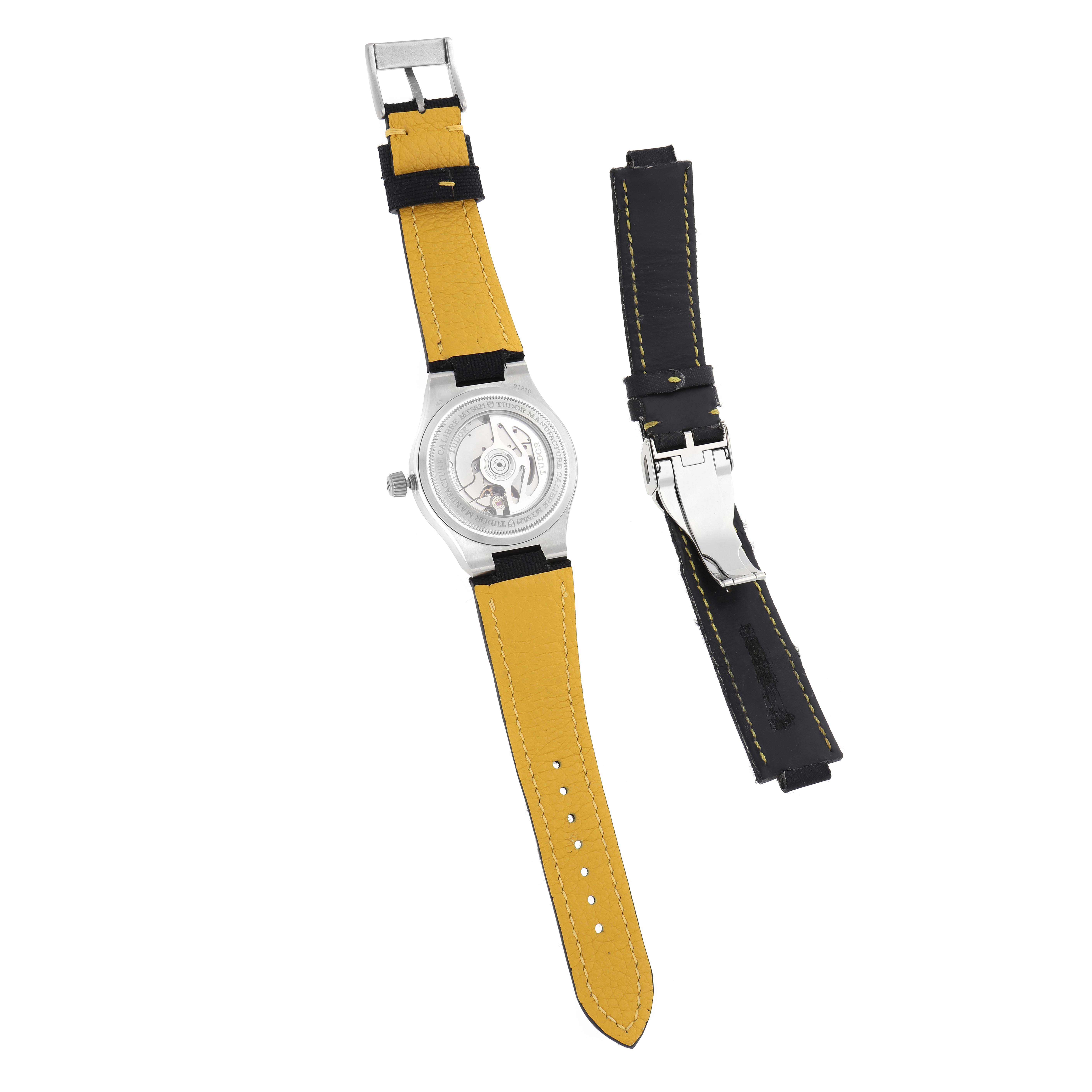 The Tudor Pelagos 91210N Men
s Stainless Steel Black Dial watch is shown from the back, revealing its movement and strap, alongside an additional strap.