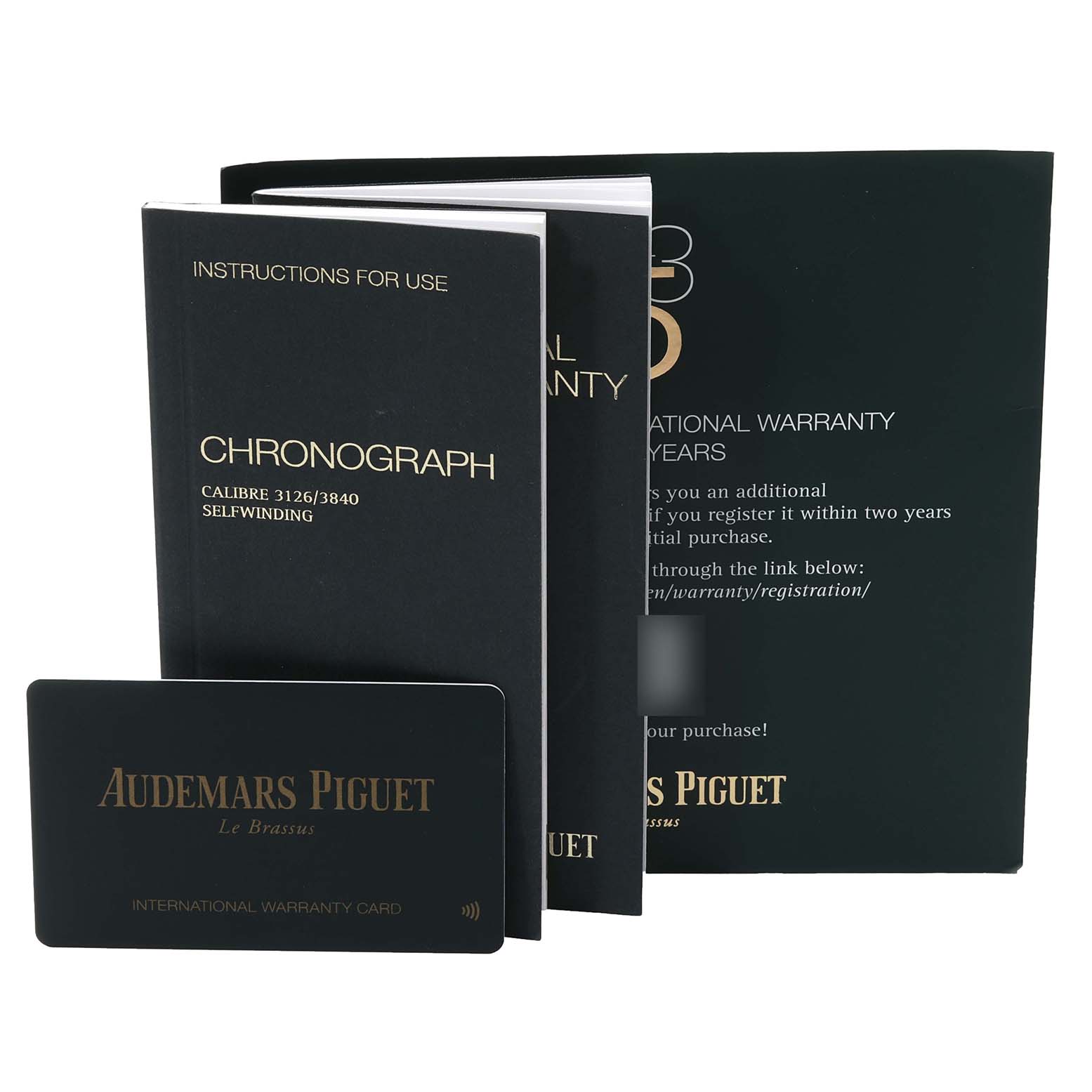 The image shows a Royal Oak Offshore model by Audemars Piguet's instruction manuals and international warranty card laid out.