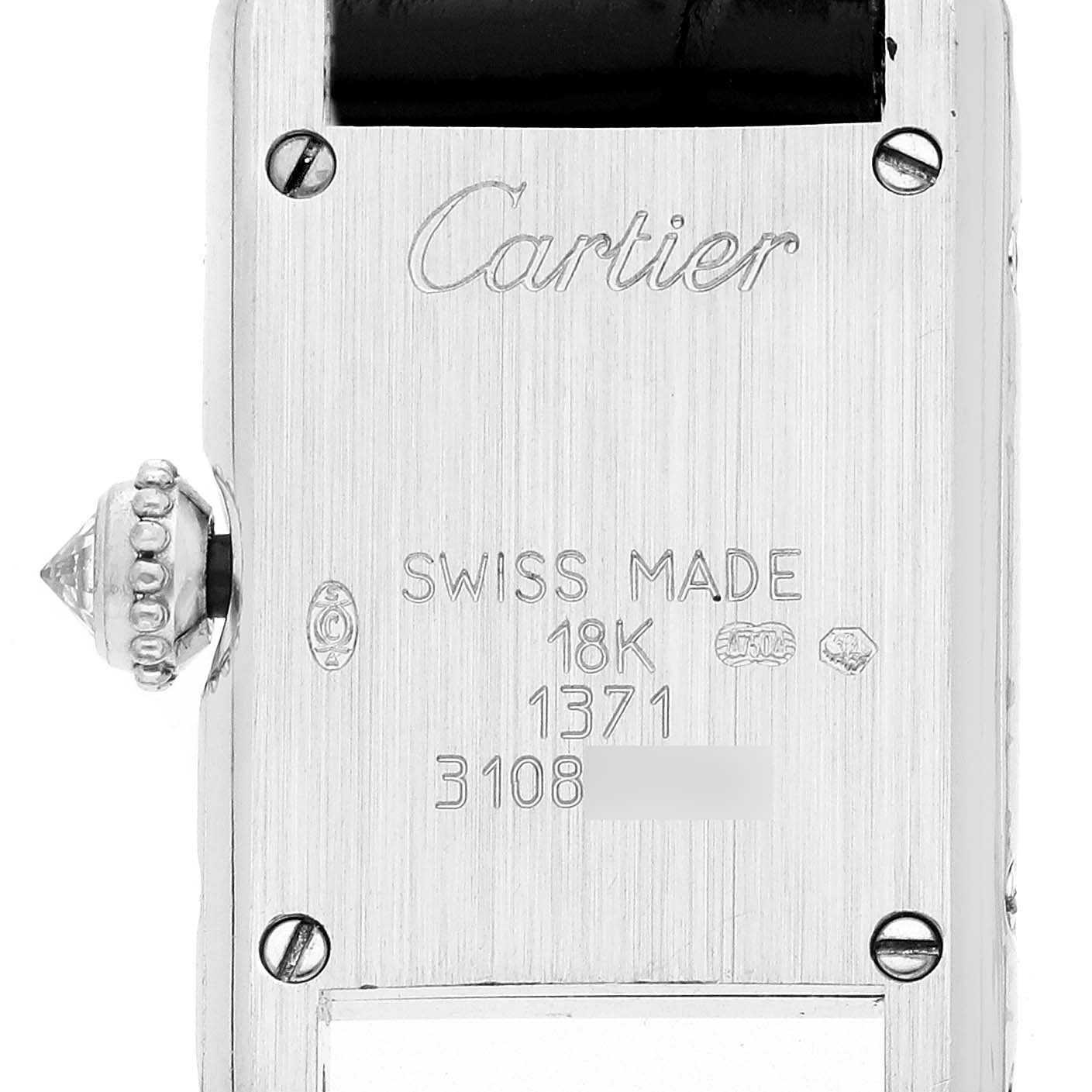 The image shows the back of a Cartier Tank Américaine watch, highlighting the engraved details and crown.