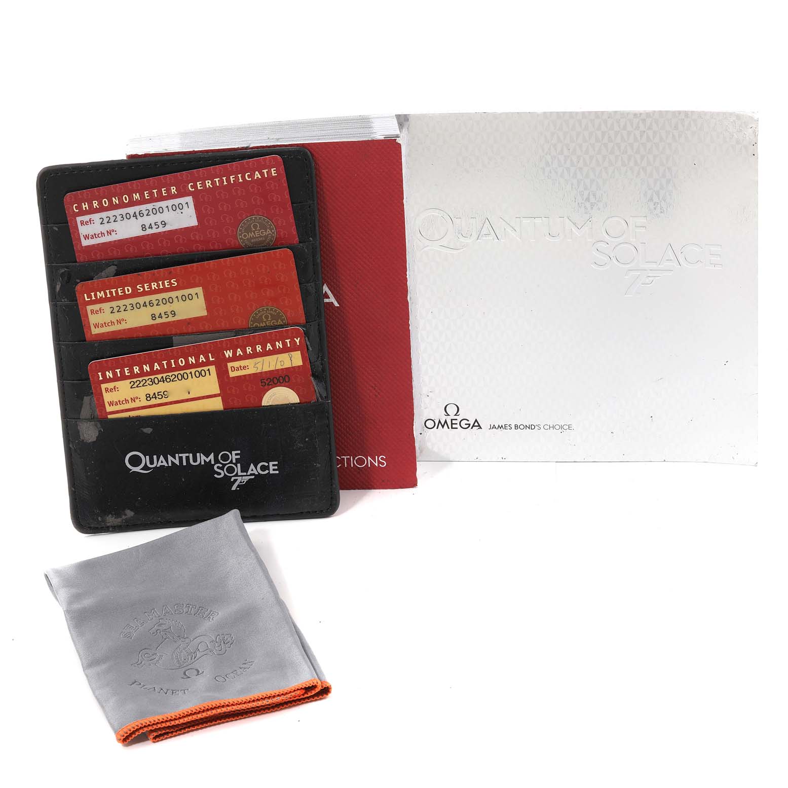 The image shows the accessories for a Planet Ocean model by Omega, including warranty cards, booklets, and a cleaning cloth.